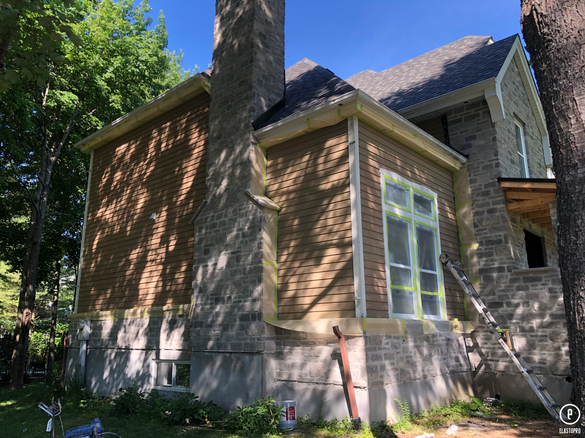 une grande maison en brique avec une cheminée en travaux