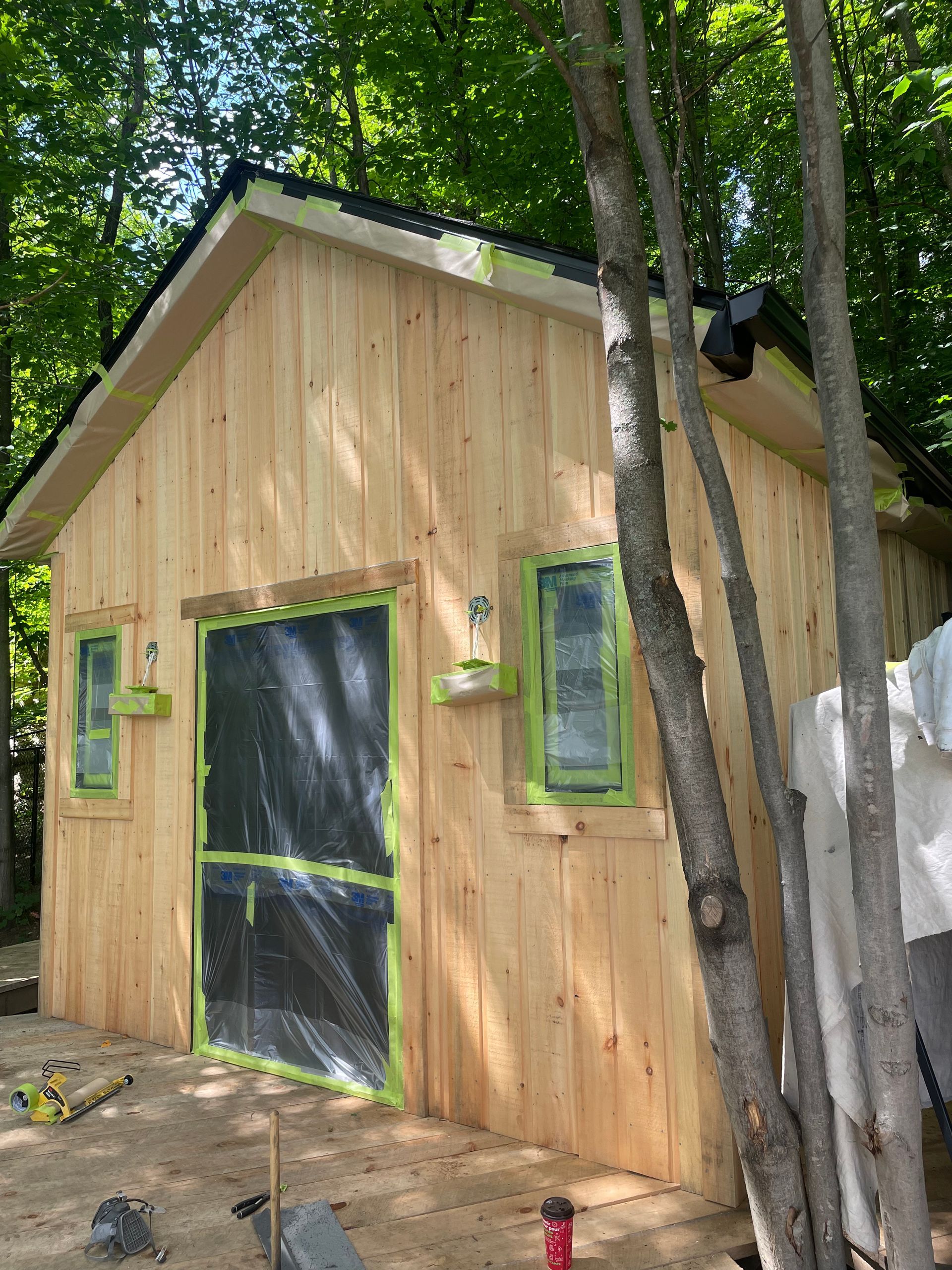 un hangar en bois est en train d'être peint dans les bois.