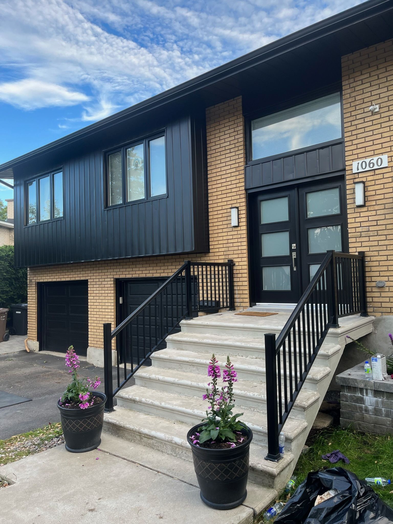 une grande maison avec bardage et escaliers noirs est à vendre.