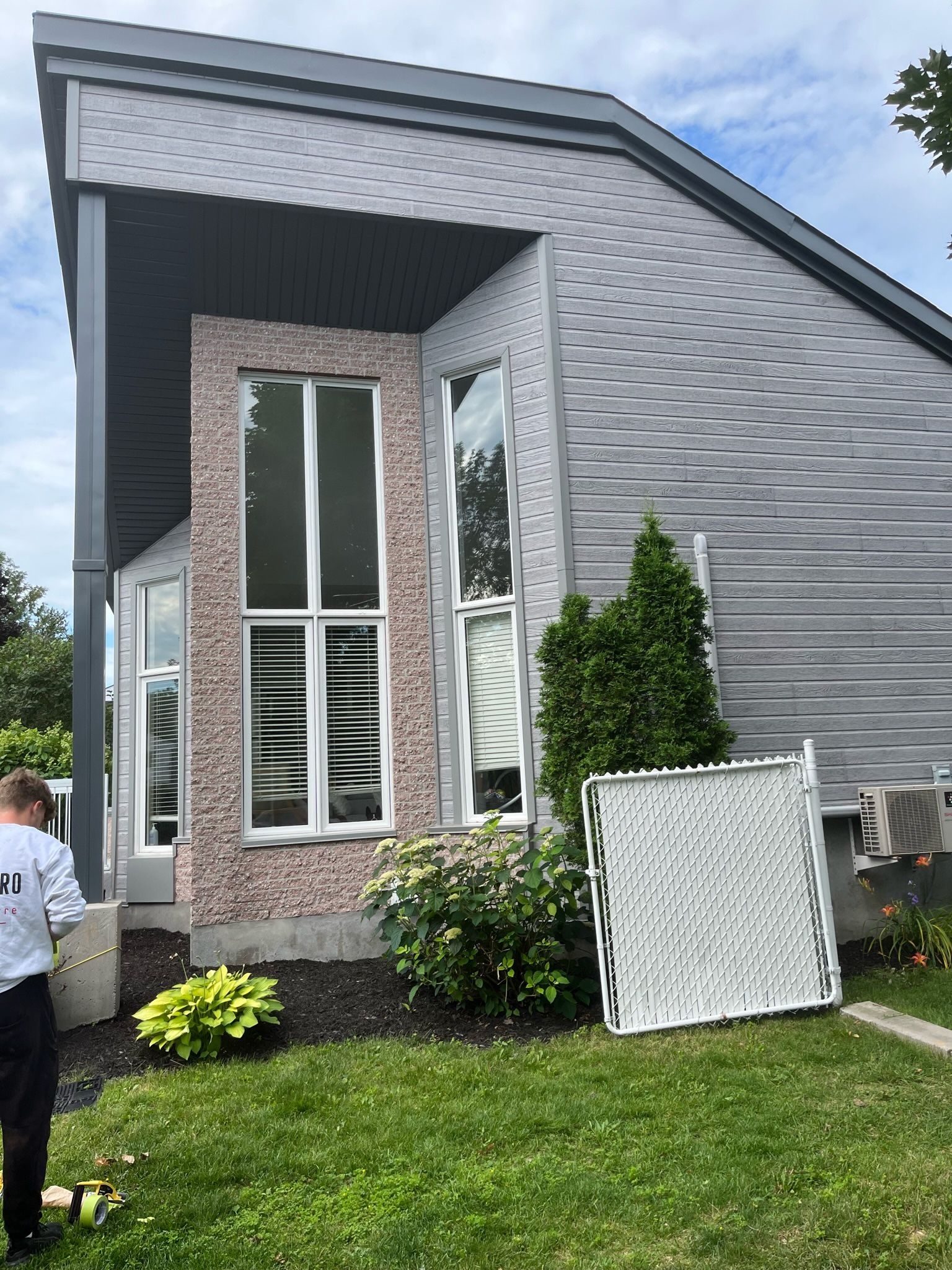 un homme se tient devant une maison avec une grande fenêtre