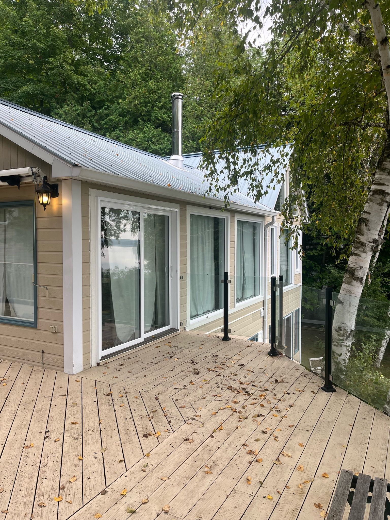 une maison avec une grande terrasse à côté d'un plan d'eau.