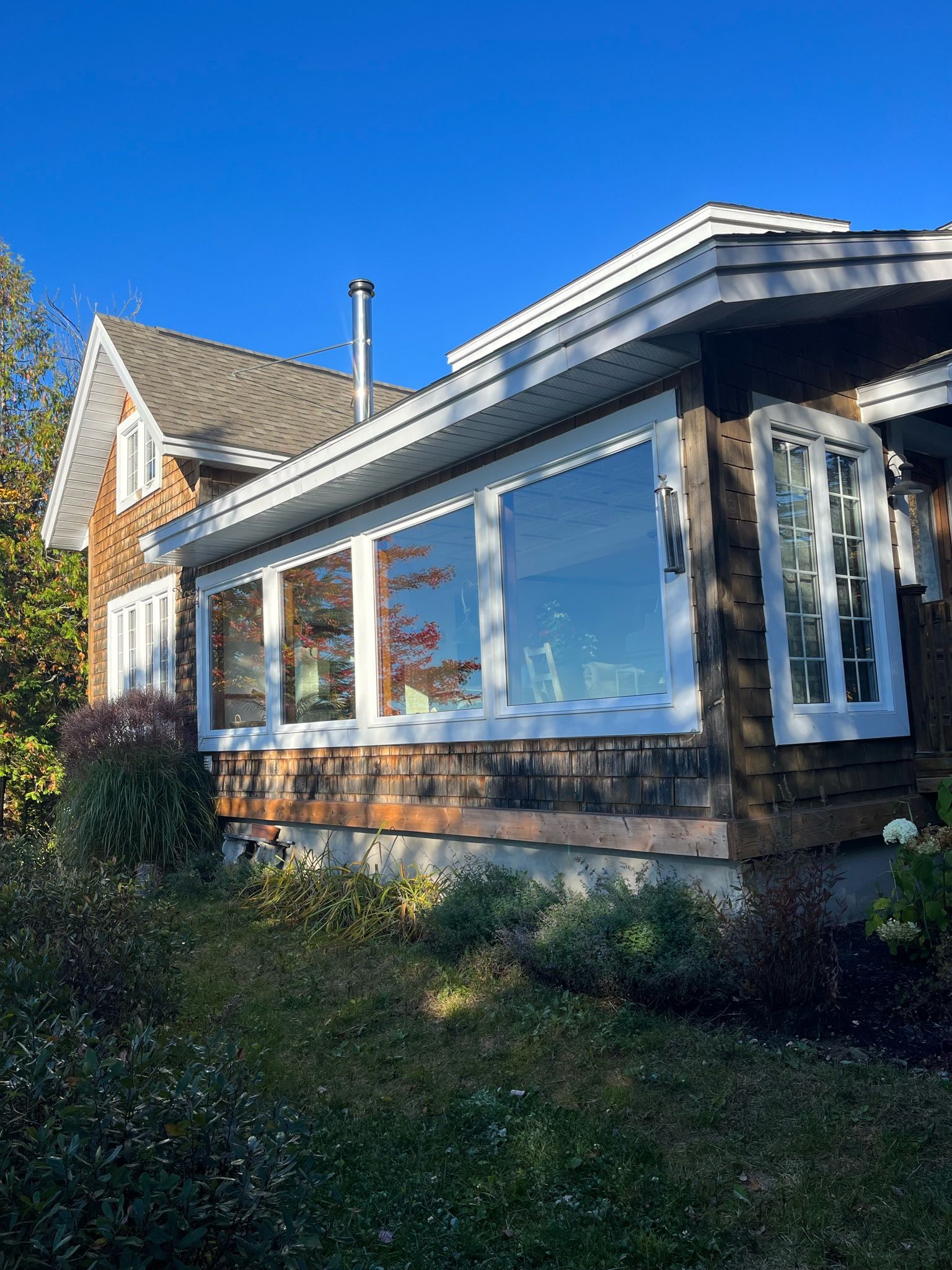 une maison avec beaucoup de fenêtres et un ciel bleu en arrière-plan.
