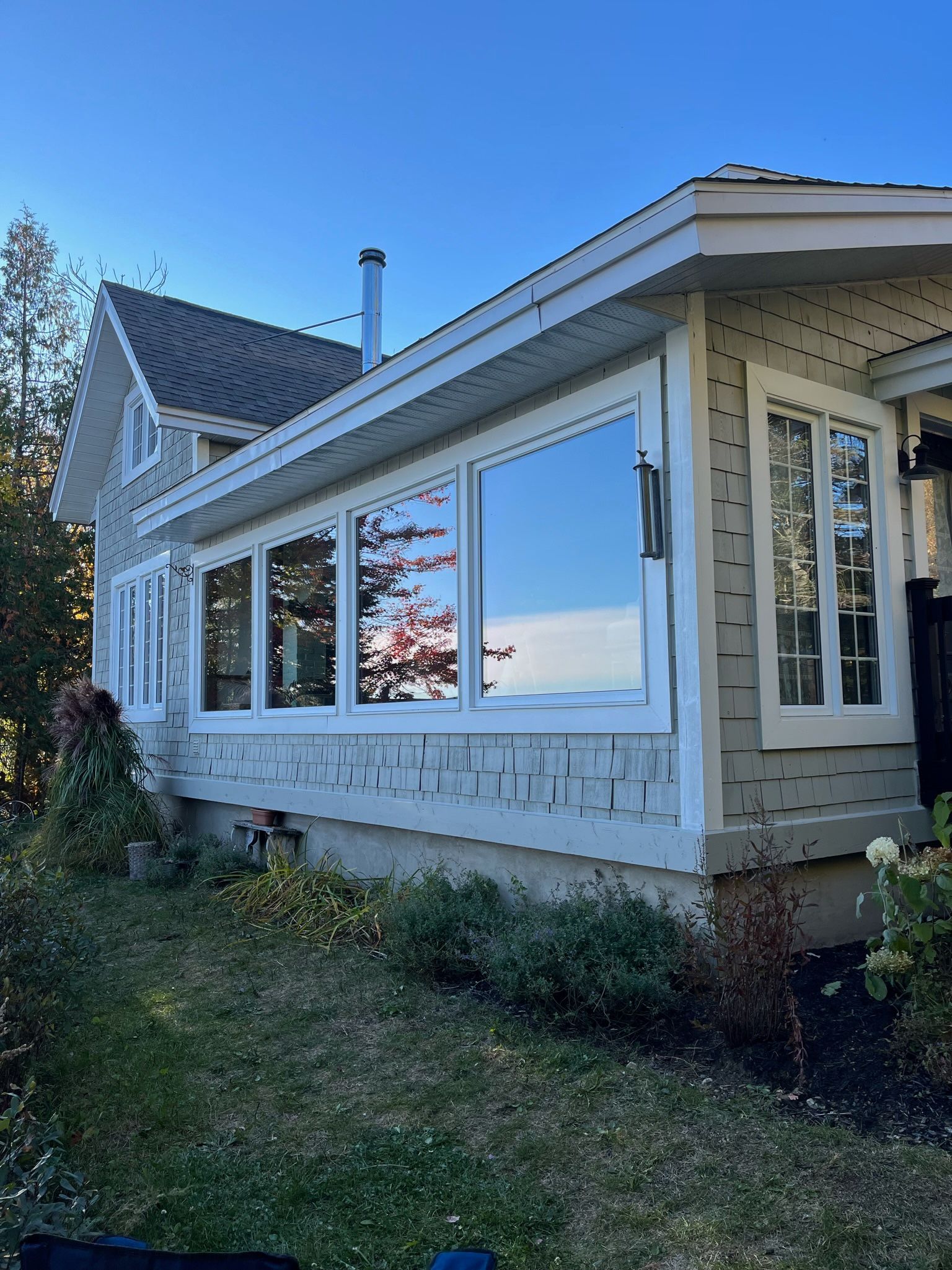 une maison avec beaucoup de fenêtres et un ciel bleu en arrière-plan.