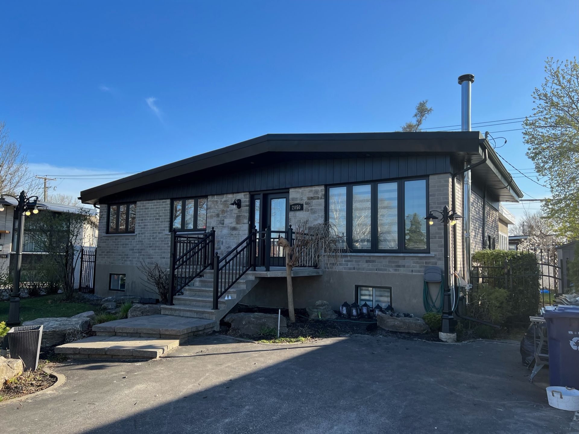 une grande maison avec beaucoup de fenêtres et d'escaliers devant.