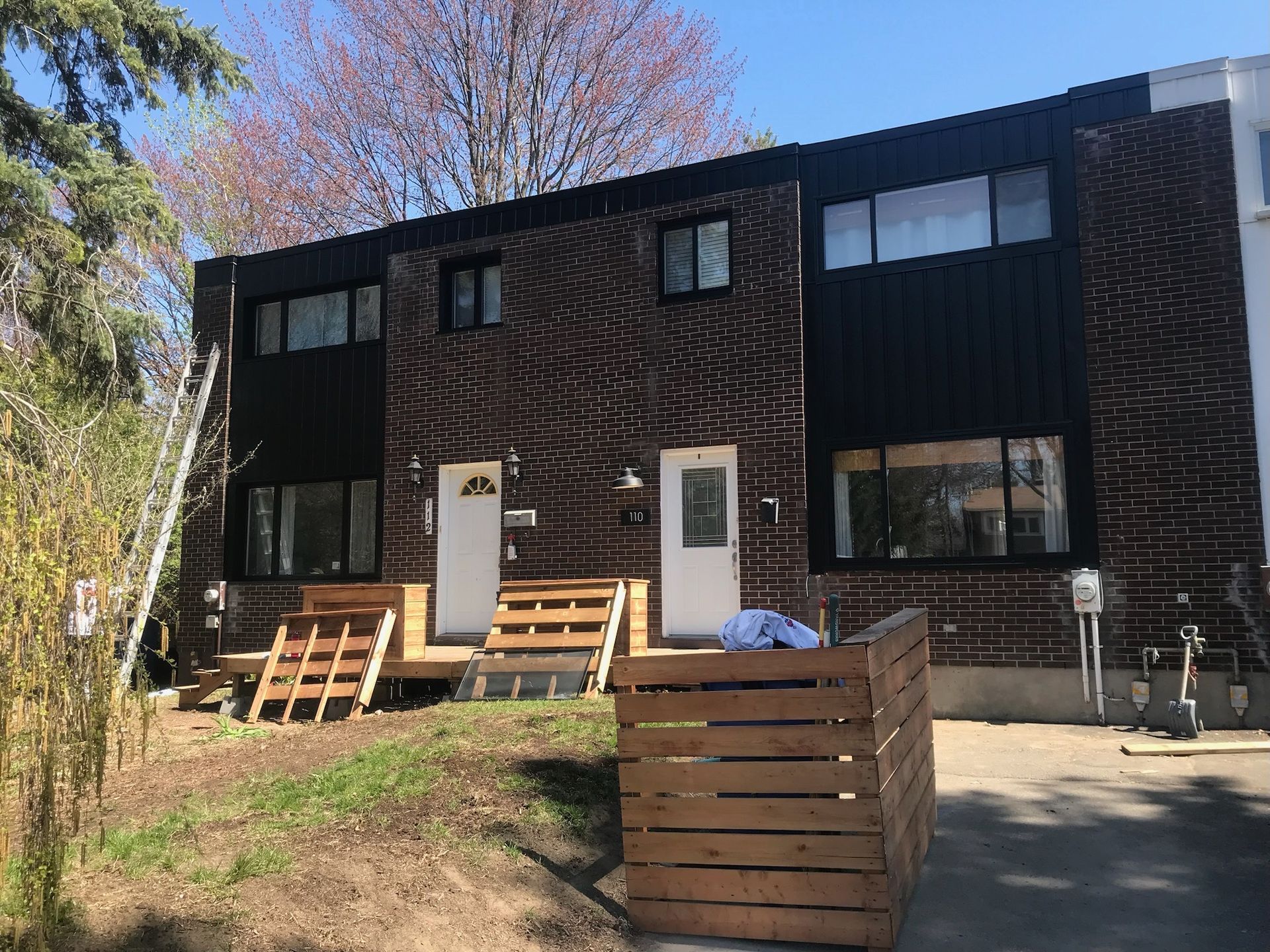 une grande maison en brique avec une clôture en bois devant.