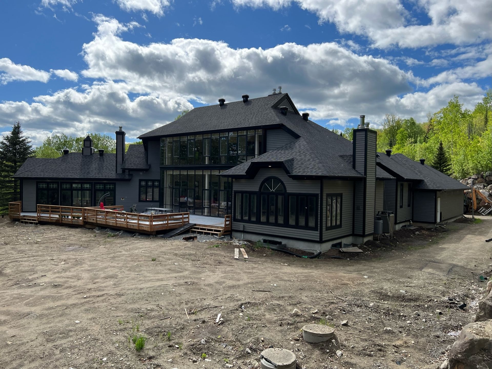 une grande maison est en construction au milieu d'un champ de terre.
