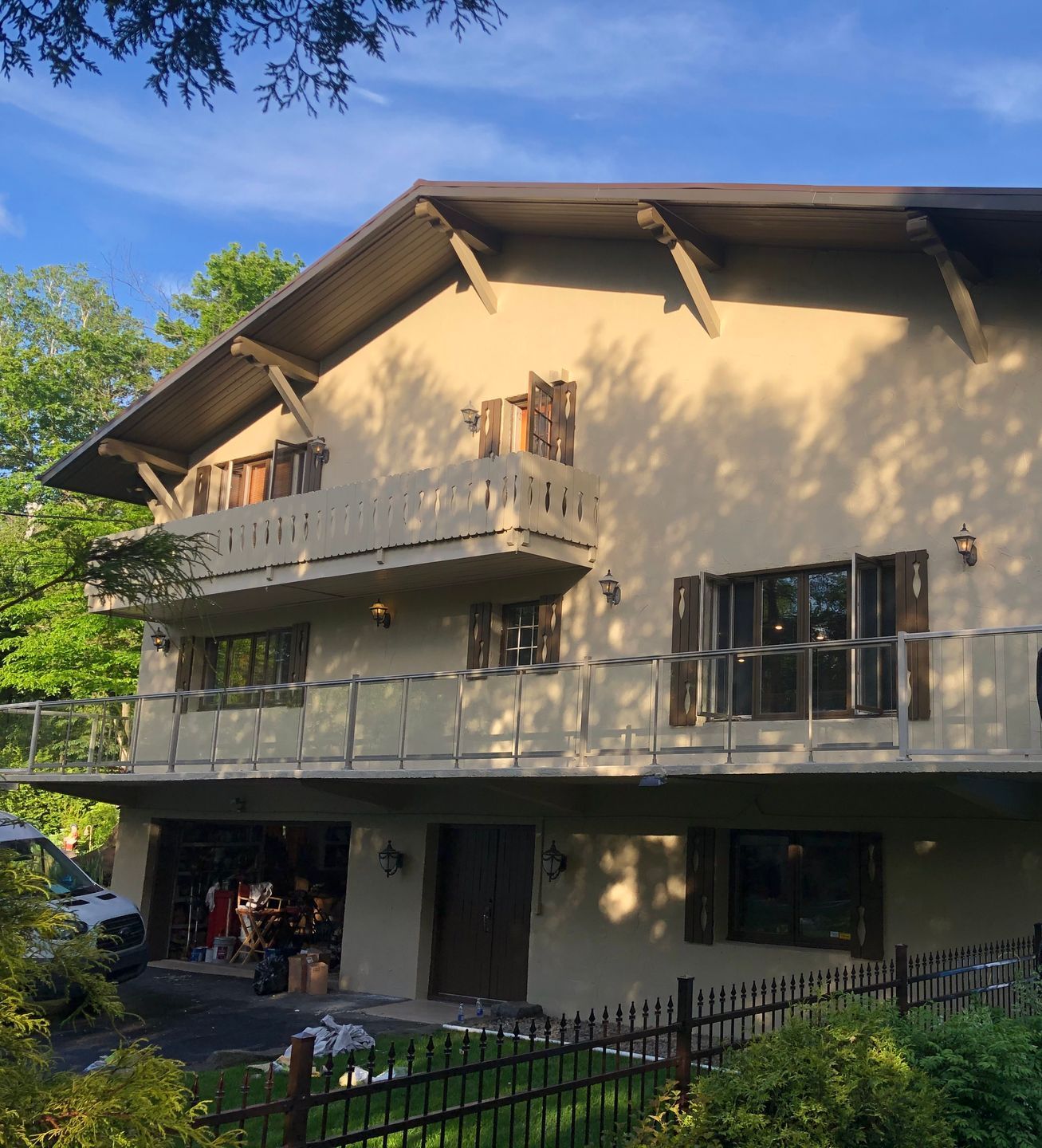 une grande maison avec un balcon et une clôture autour