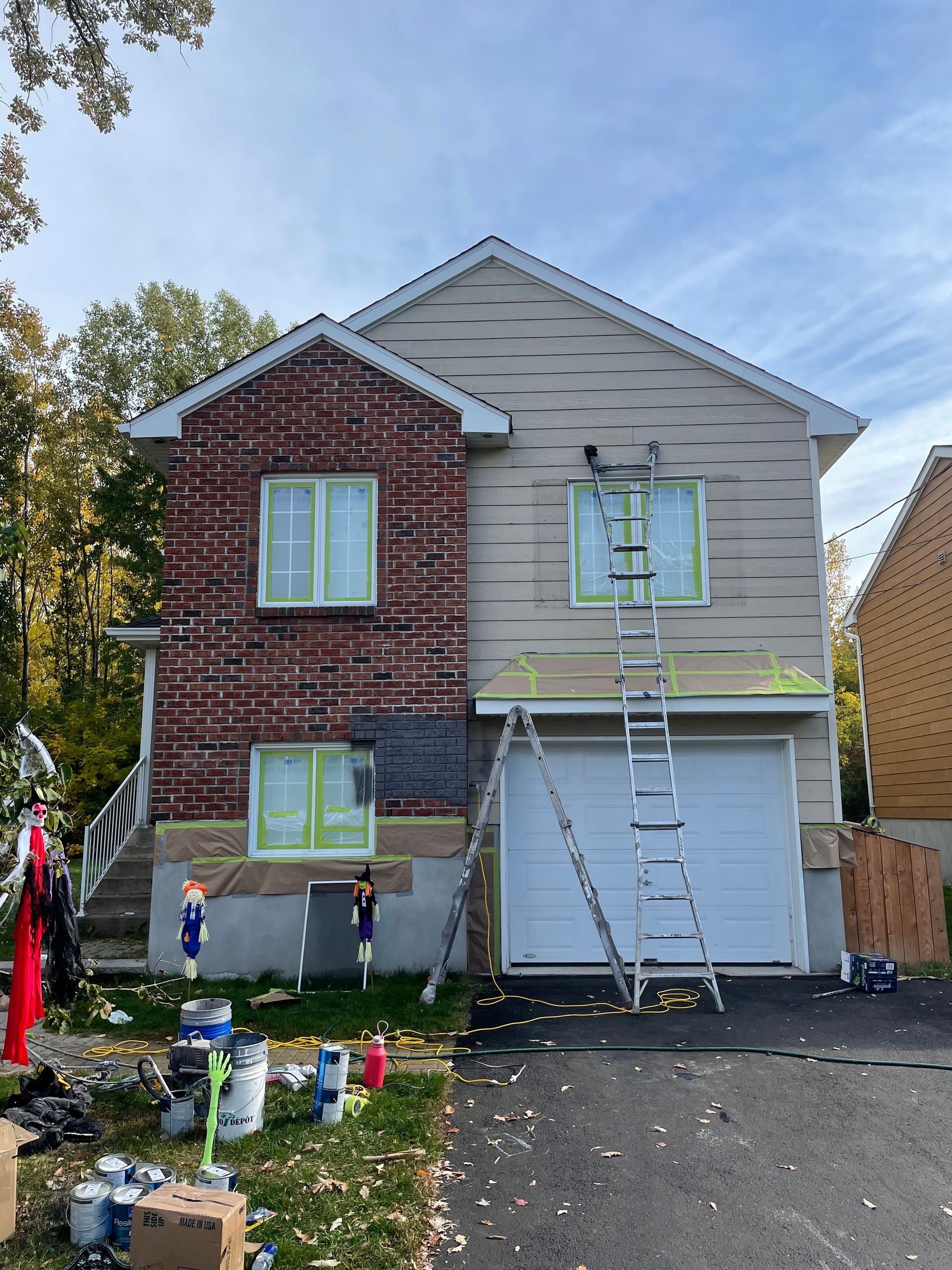 A house is being painted with a ladder in front of it.