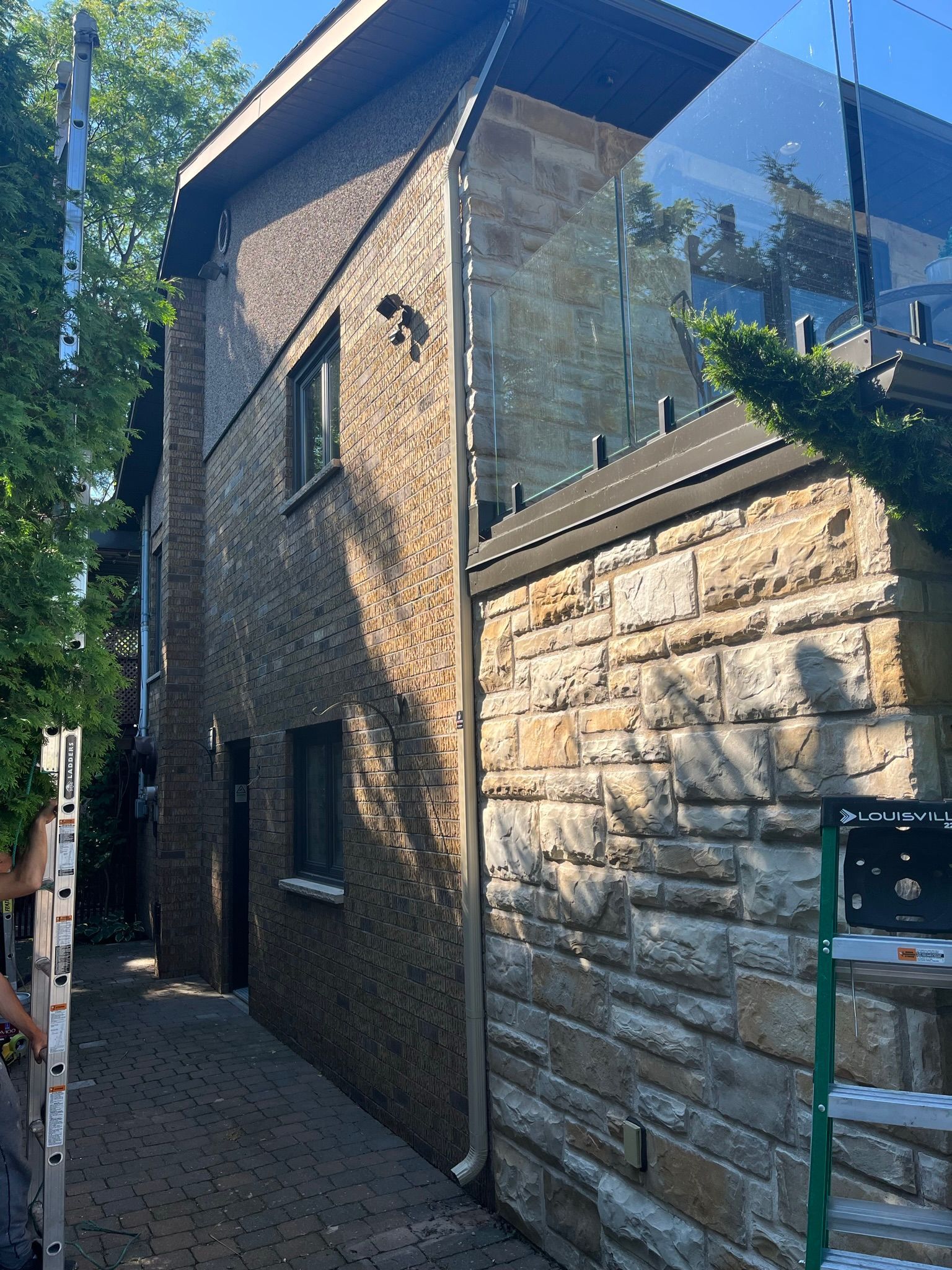 un bâtiment en brique avec un balcon en verre sur le côté.