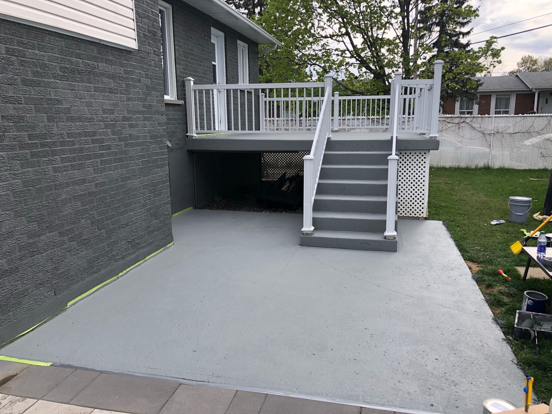 une terrasse en béton avec des escaliers qui y mènent est peinte en gris.