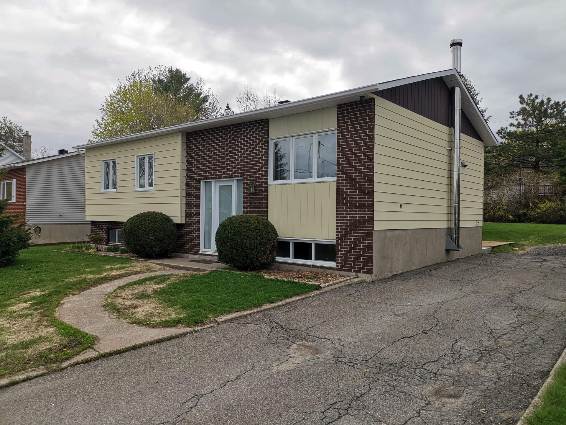 une petite maison avec beaucoup de fenêtres et une cheminée sur le côté.