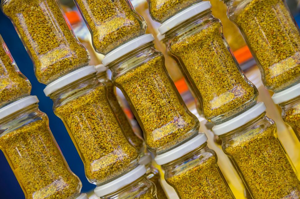 Vasetti di senape gialla in grani disposti in diagonale, coperchi bianchi, vista ravvicinata.