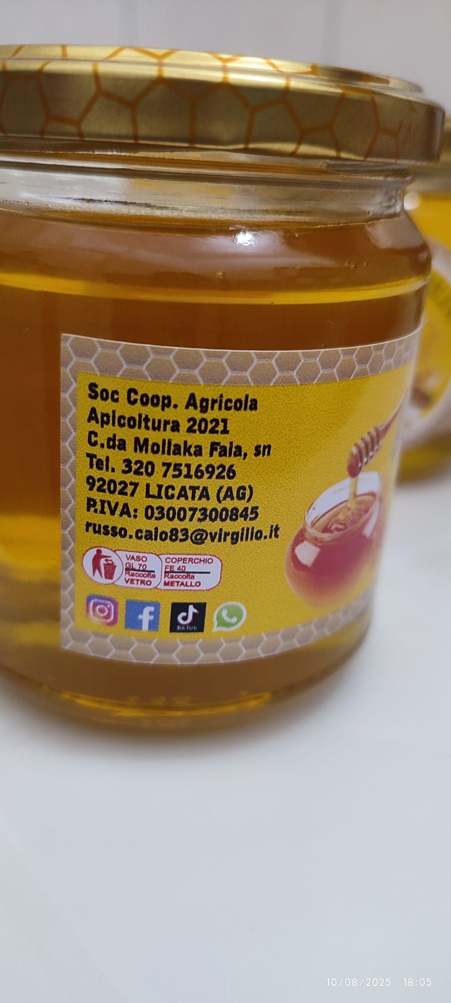 Un barattolo di miele con un'etichetta gialla su cui sono raffigurati testo e icone dei social media