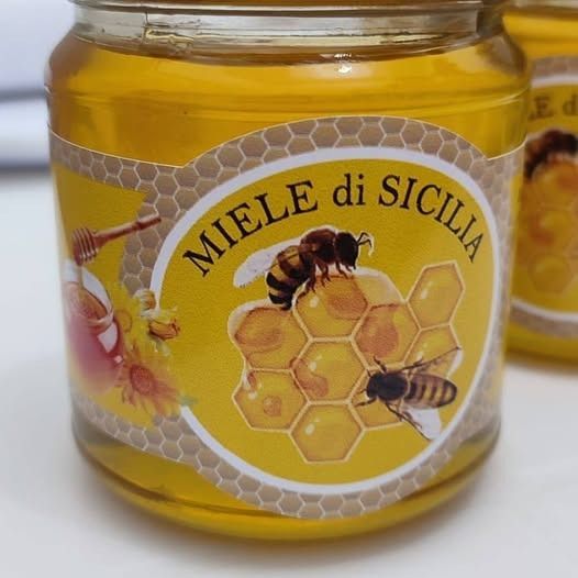 Barattolo di miele siciliano con etichetta raffigurante api su un favo.