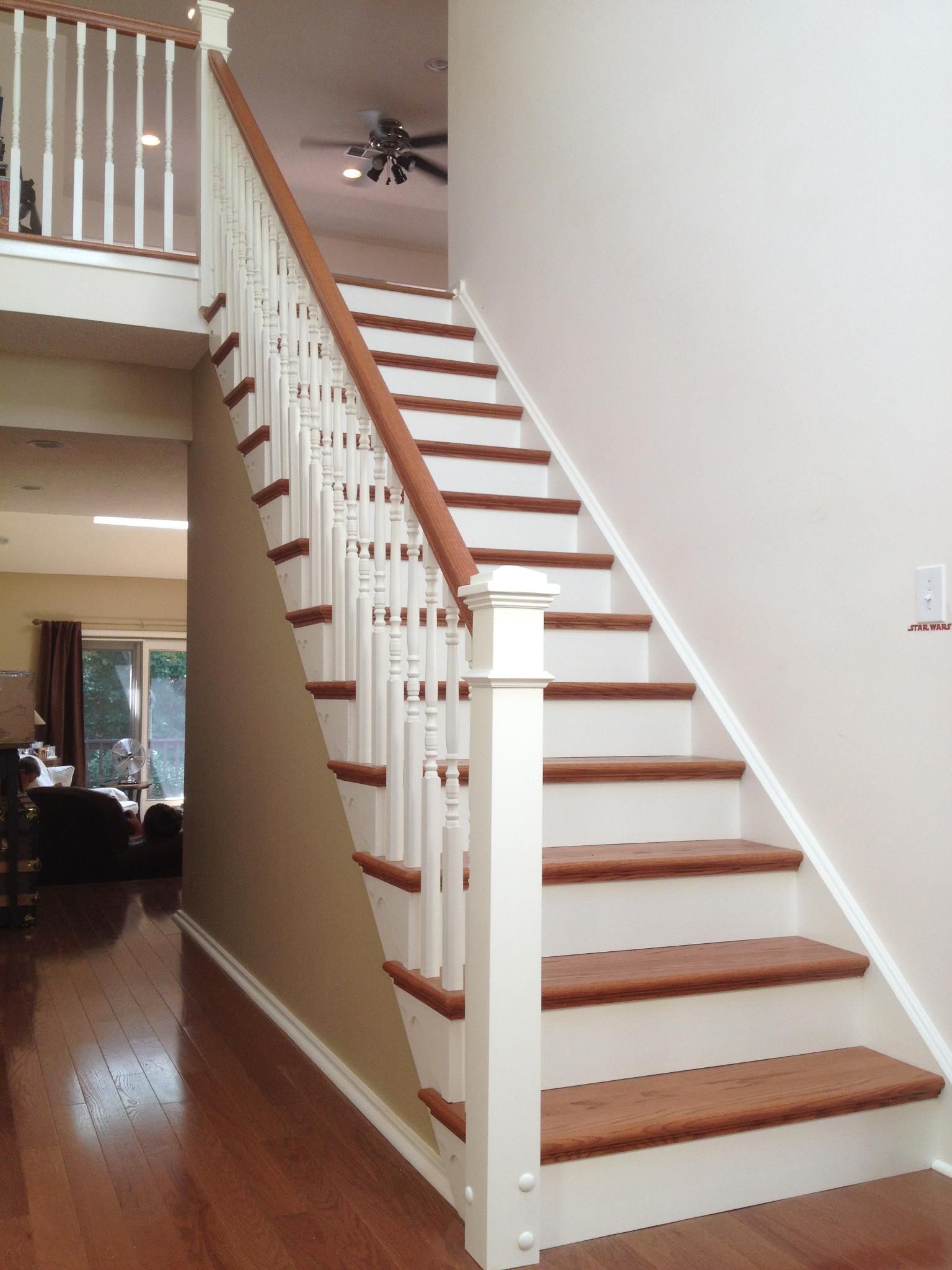 A white staircase with wooden steps in a house