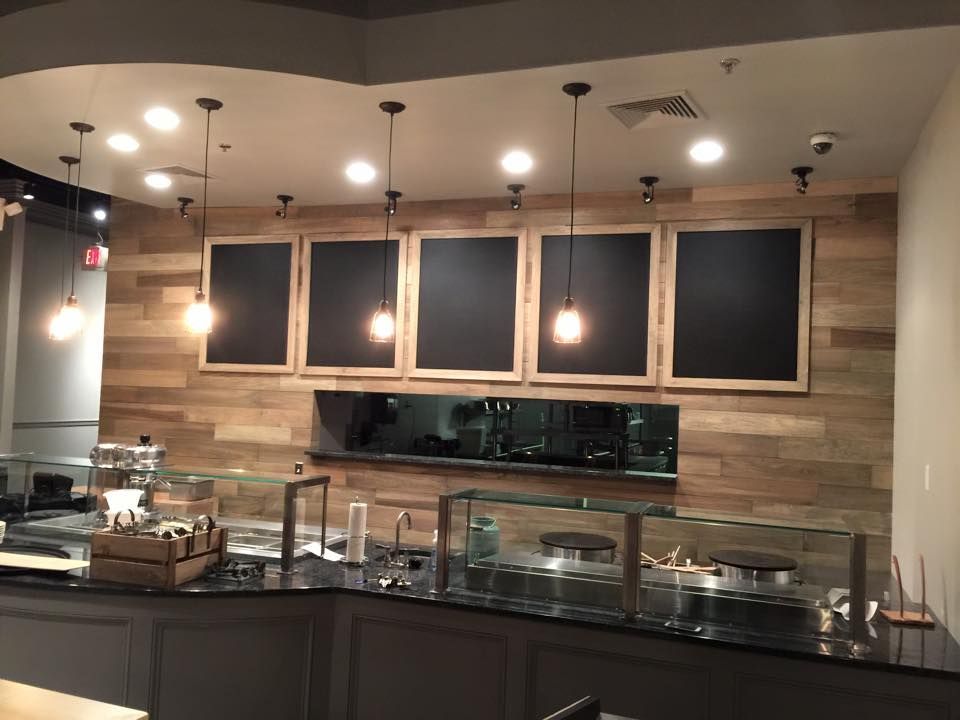 A restaurant with a counter and chalkboards on the wall