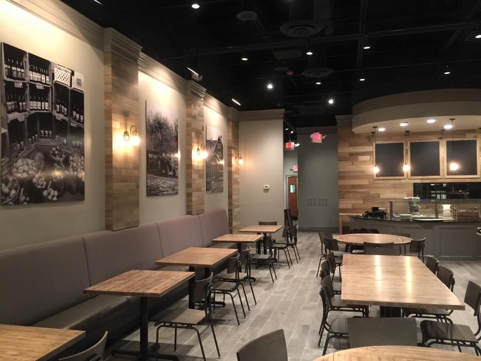 A restaurant with tables and chairs and pictures on the walls.