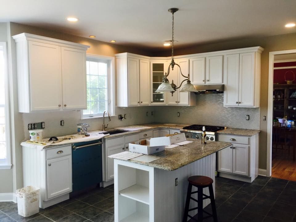 A kitchen with white cabinets and granite counter tops