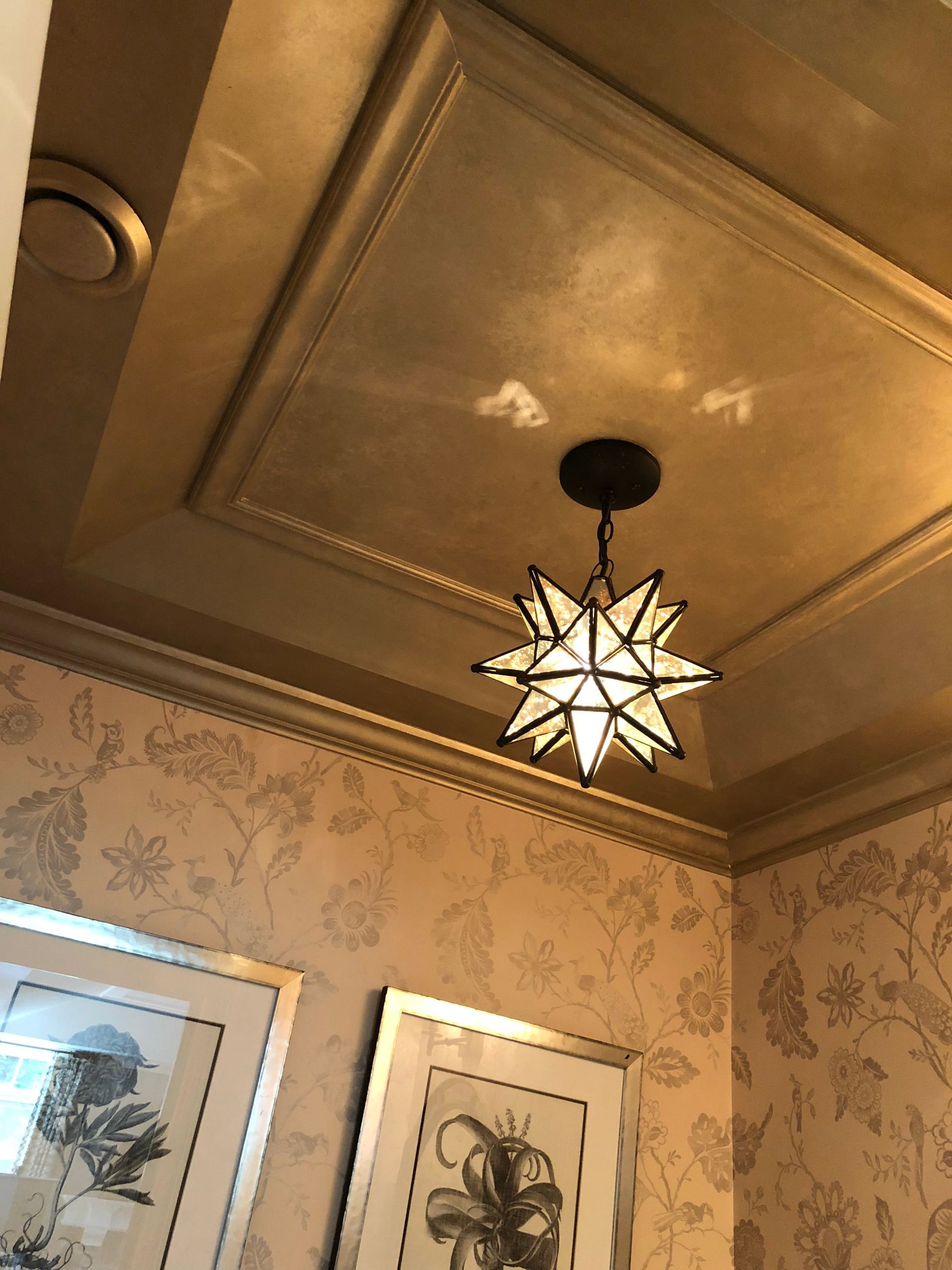 A ceiling with a star shaped light hanging from it
