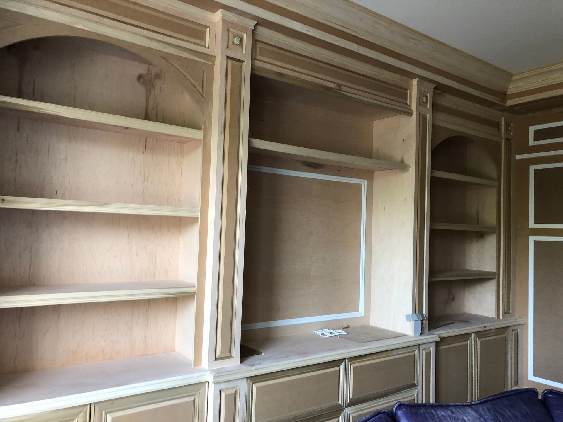 A living room with a lot of shelves and a couch.