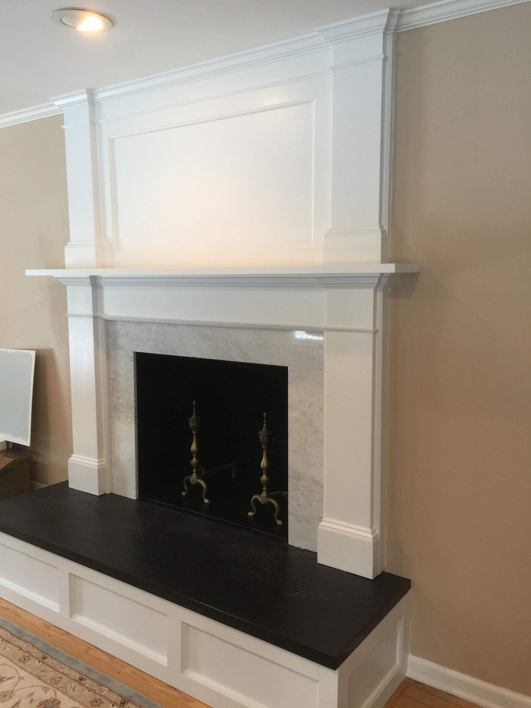 A fireplace in a living room with a white mantle