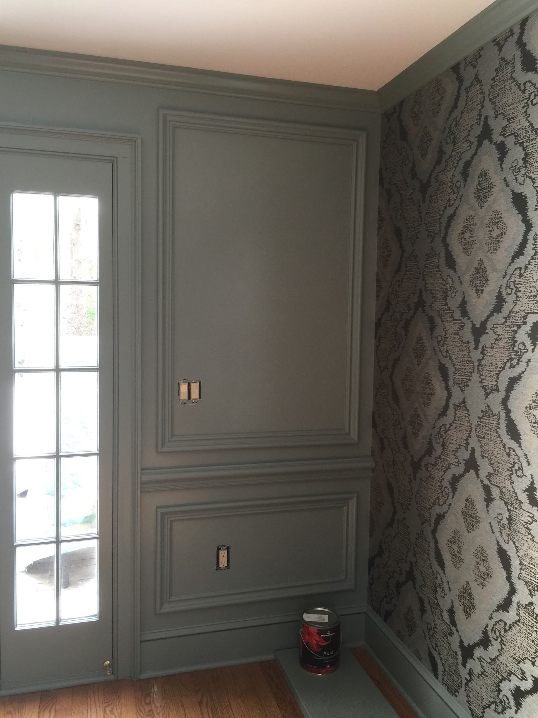 A room with a door and a wall with a patterned wallpaper