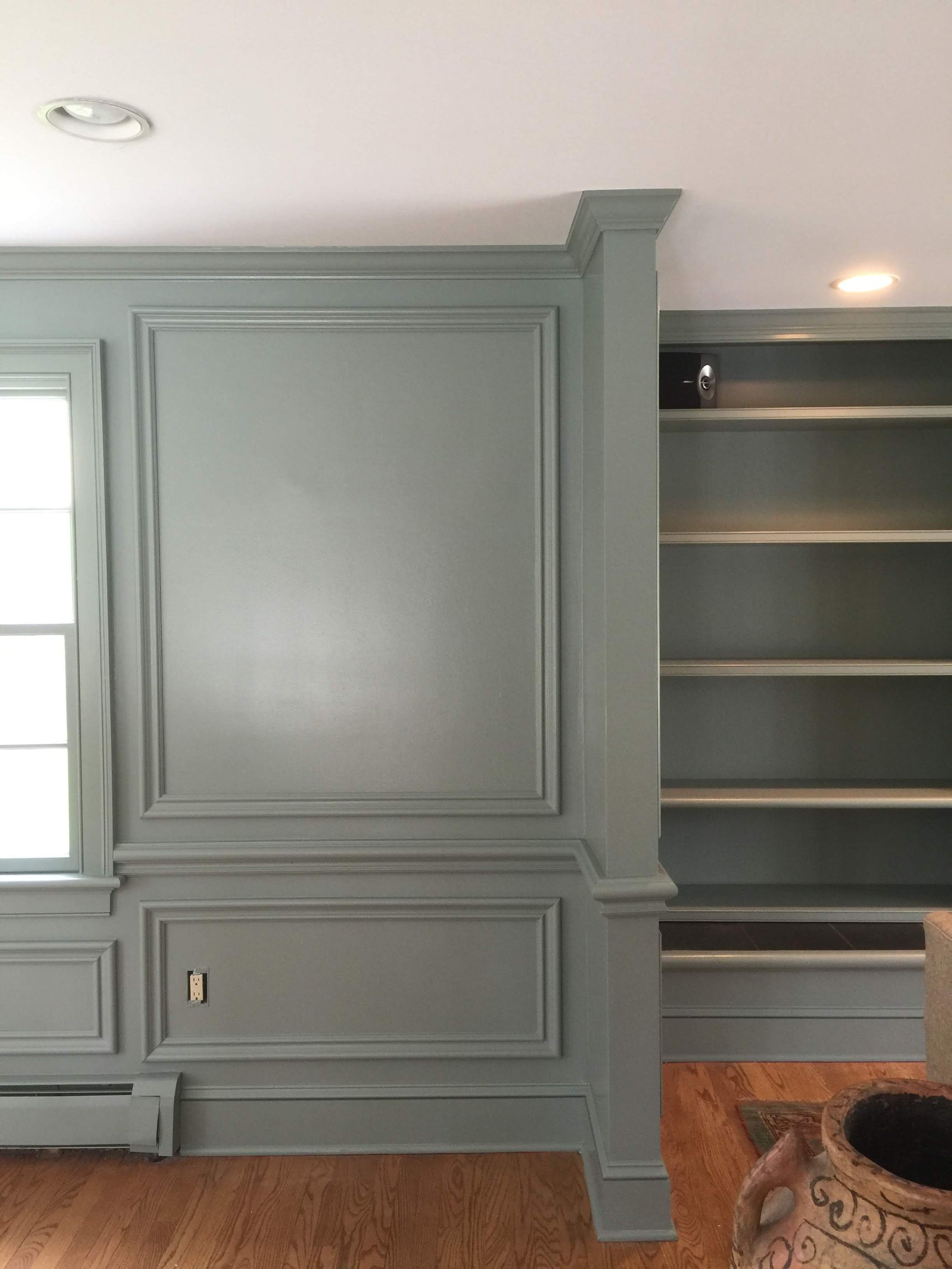 A living room with a bookshelf and a window.
