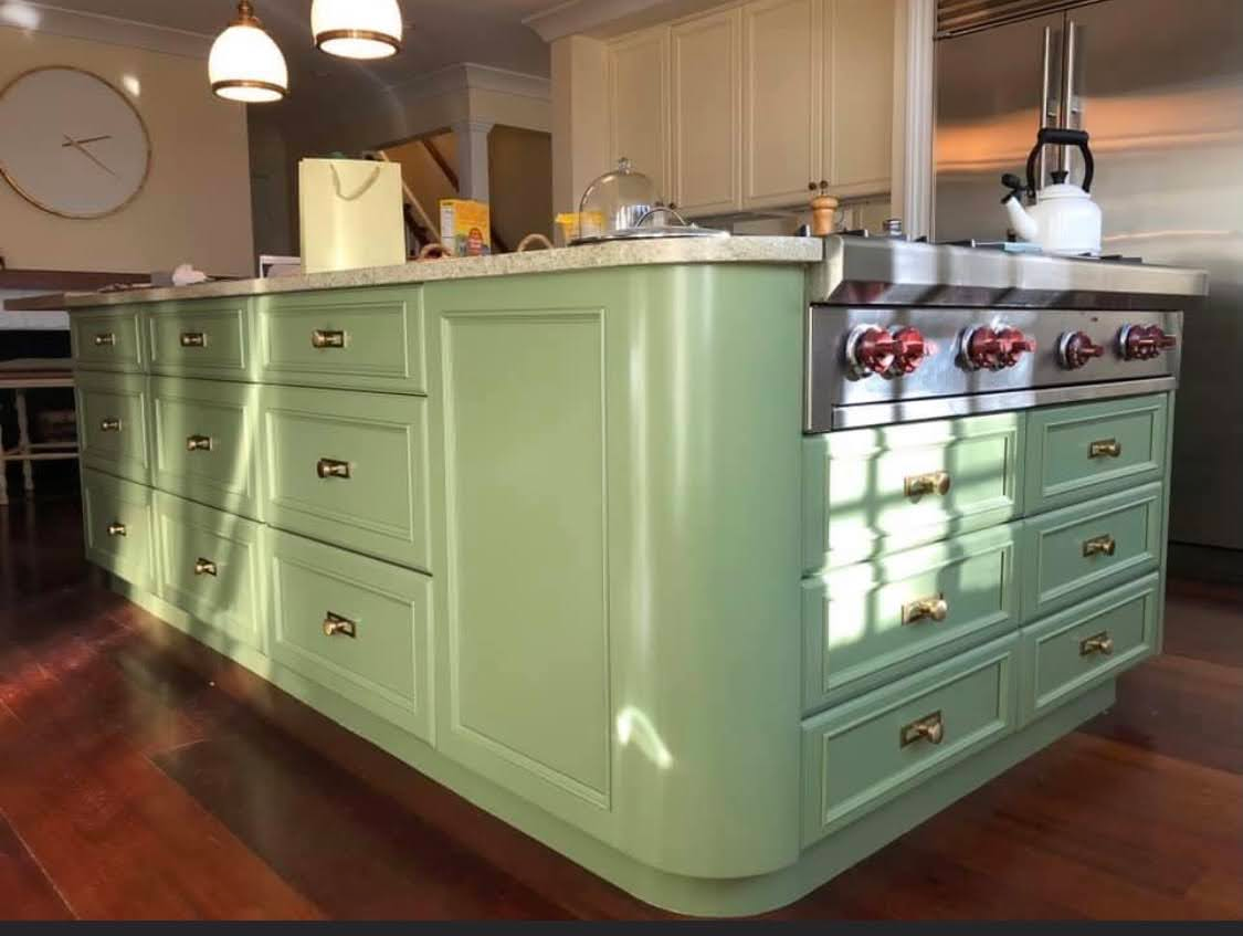 A kitchen with green cabinets and stainless steel appliances