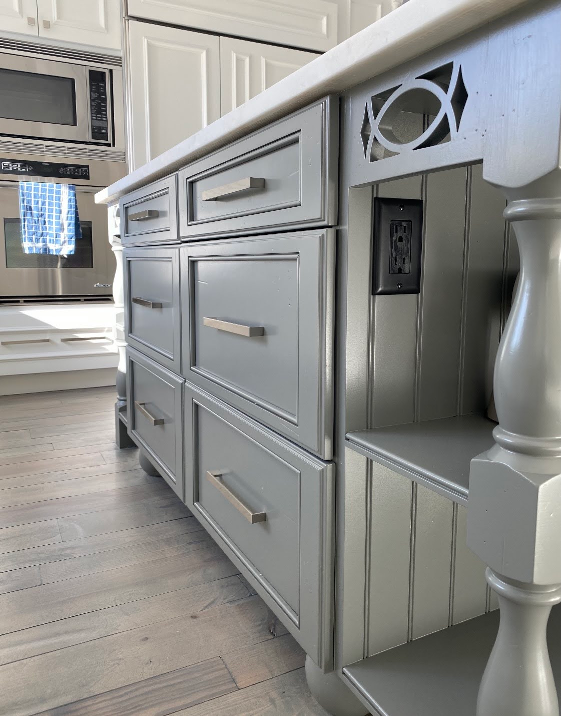 A kitchen with gray cabinets and a white counter top