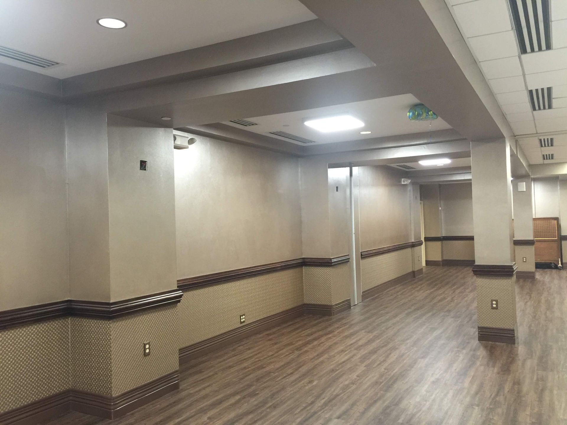 An empty hallway with wooden floors and walls in a building.