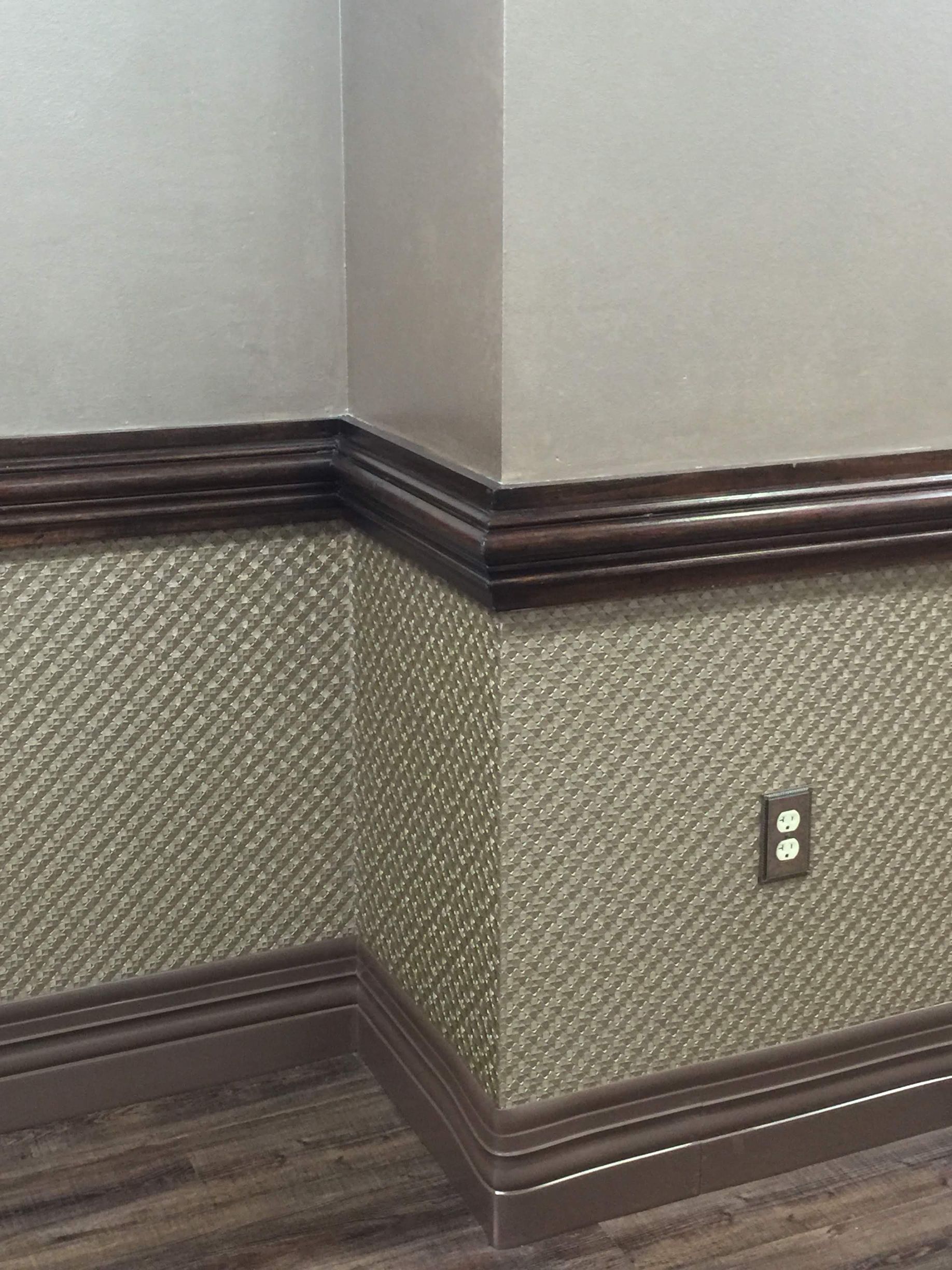 A corner of a room with a light switch on the wall.