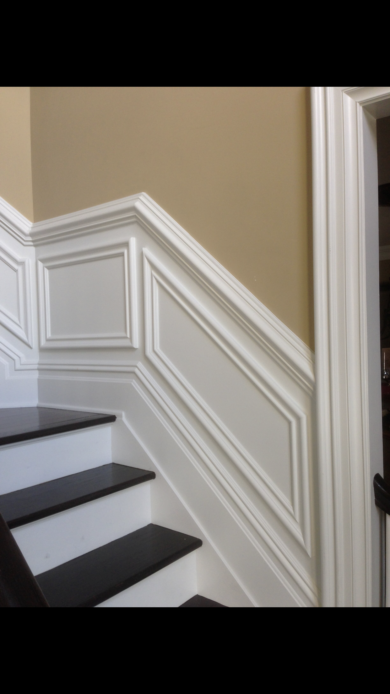 A staircase with white trim and black steps
