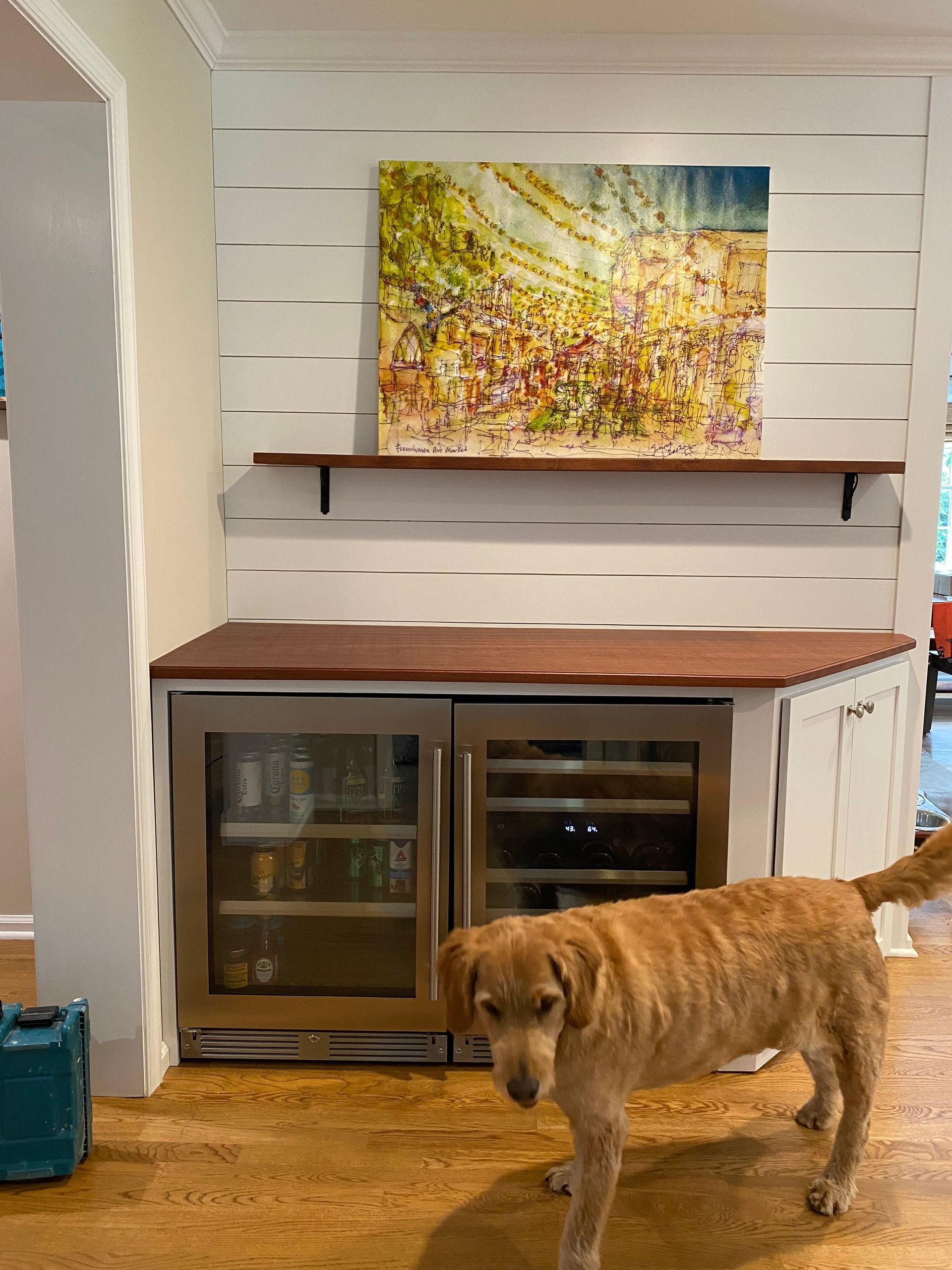 A dog is standing in front of a refrigerator in a kitchen.
