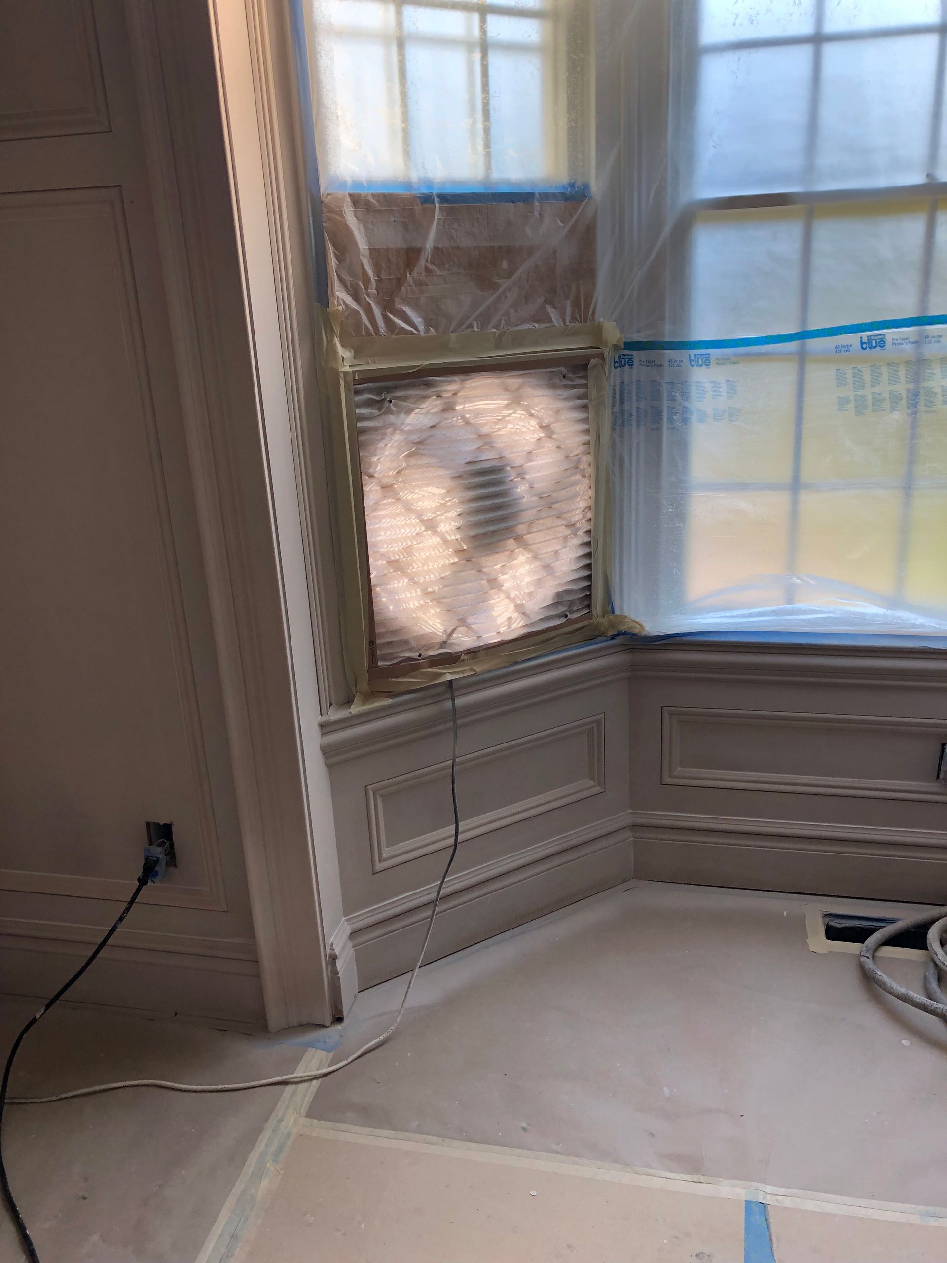 A room with a window and a fan in it.