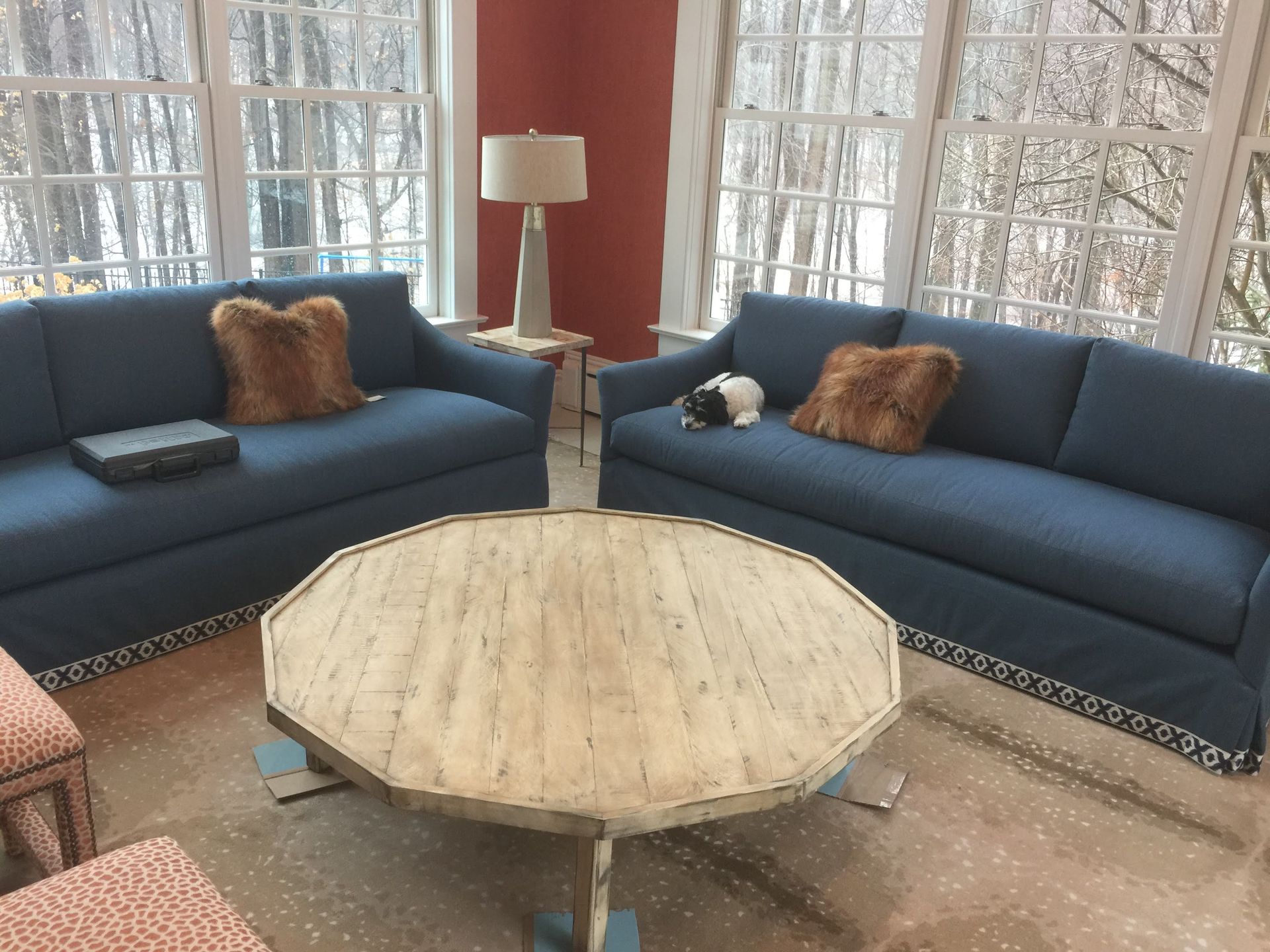 A living room with two blue couches and a round coffee table
