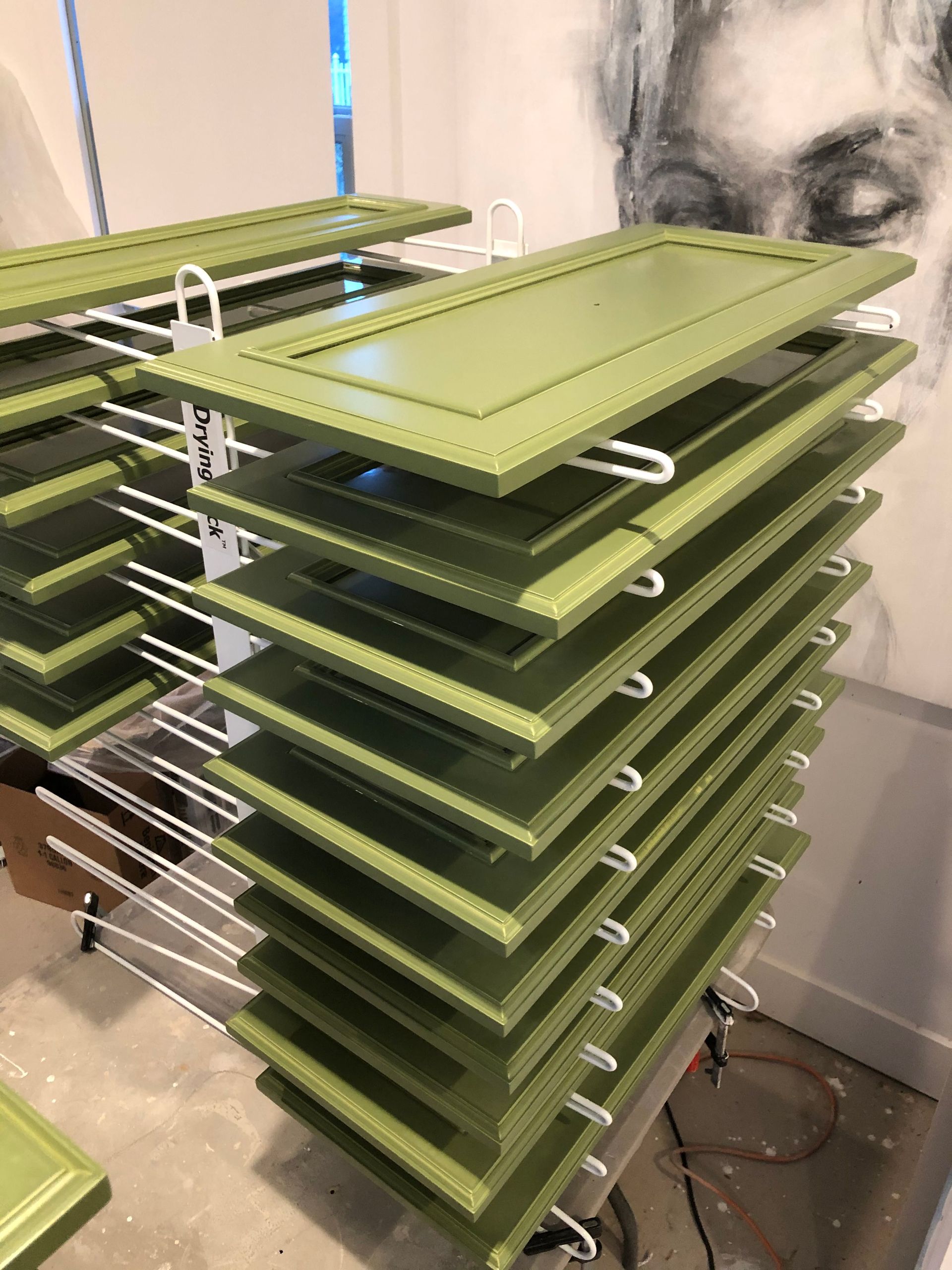A stack of green cabinet doors sitting on top of each other.