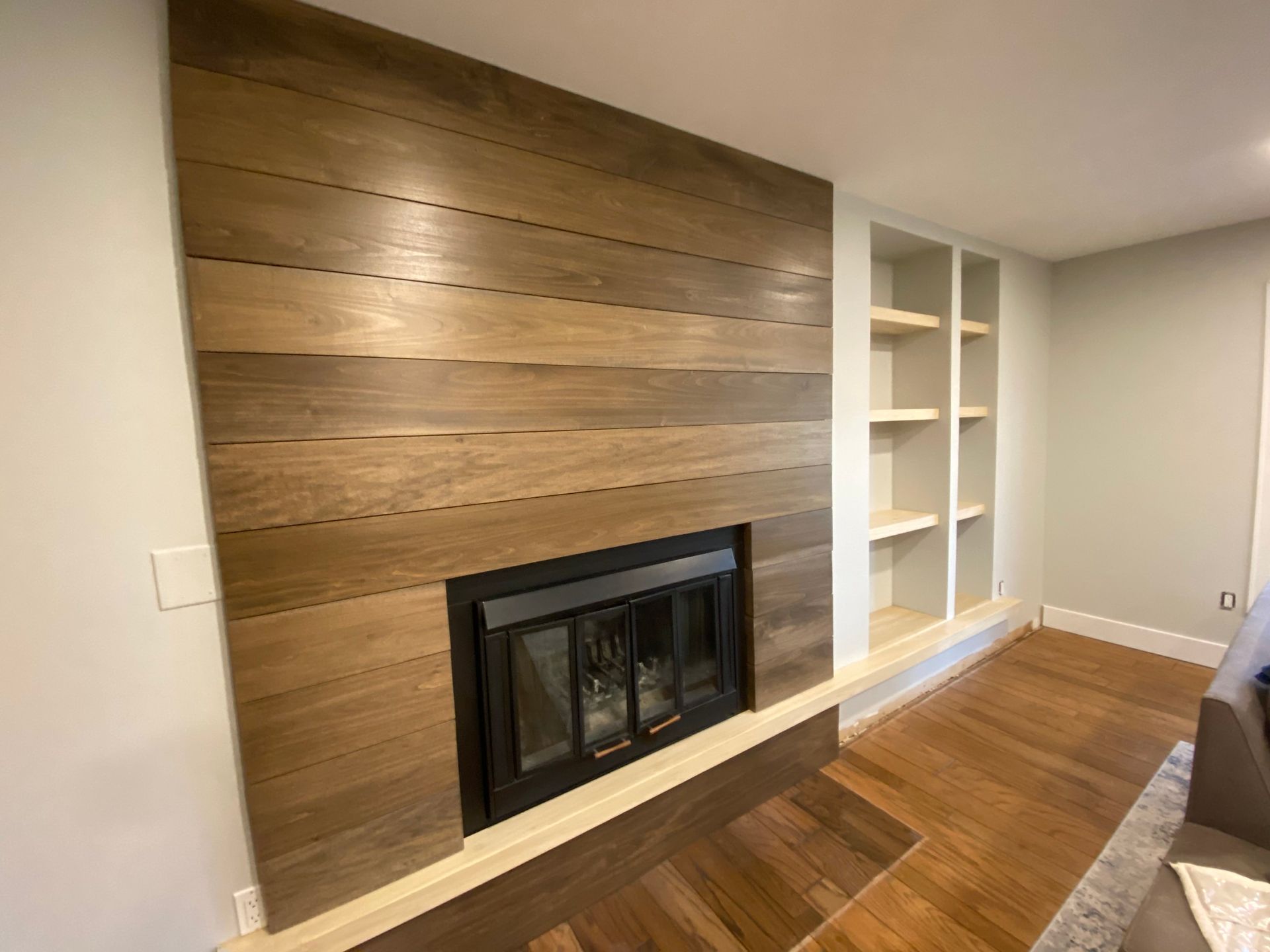 A living room with a fireplace and built in shelves.