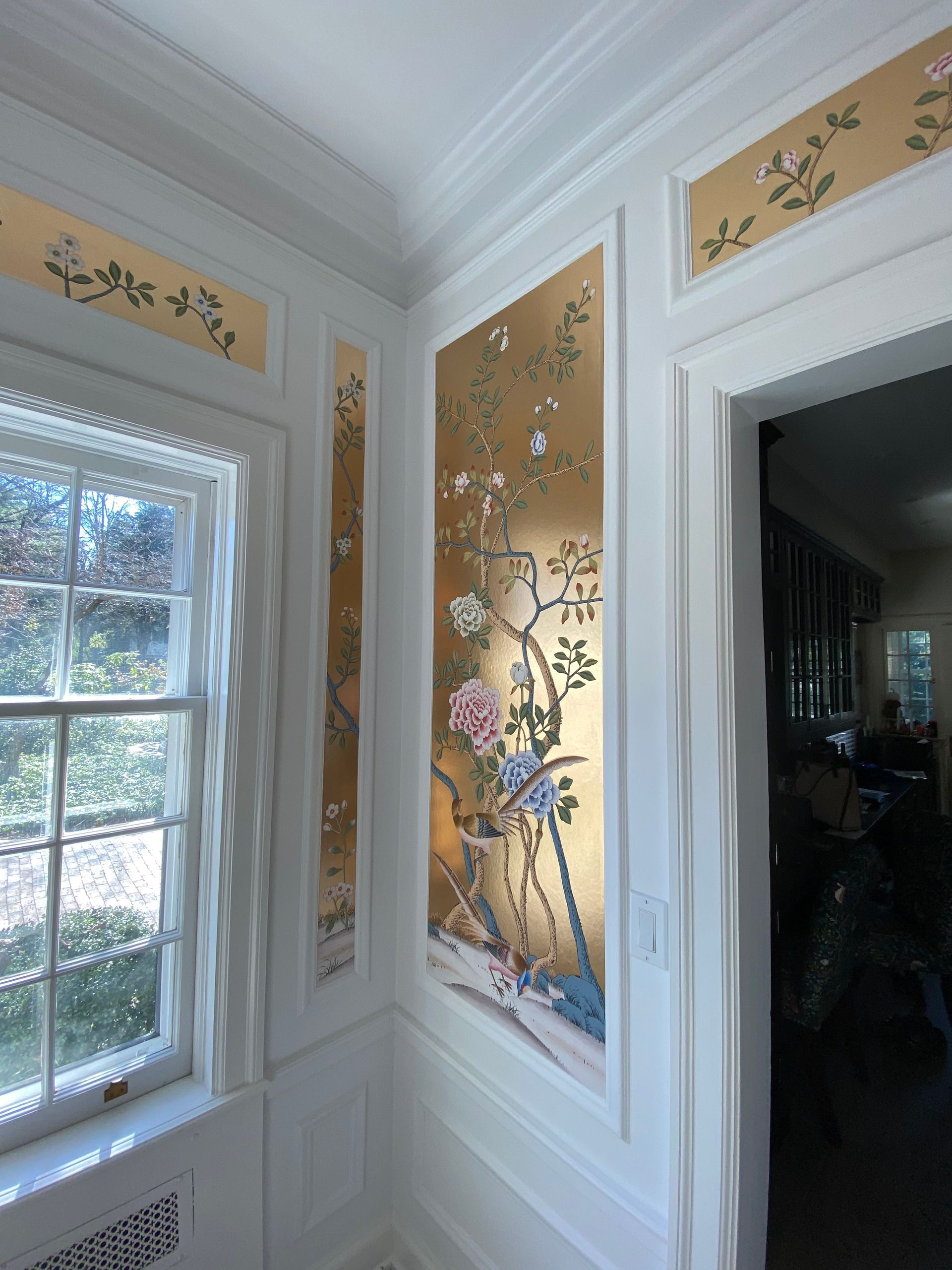 A room with a window and a painting on the wall