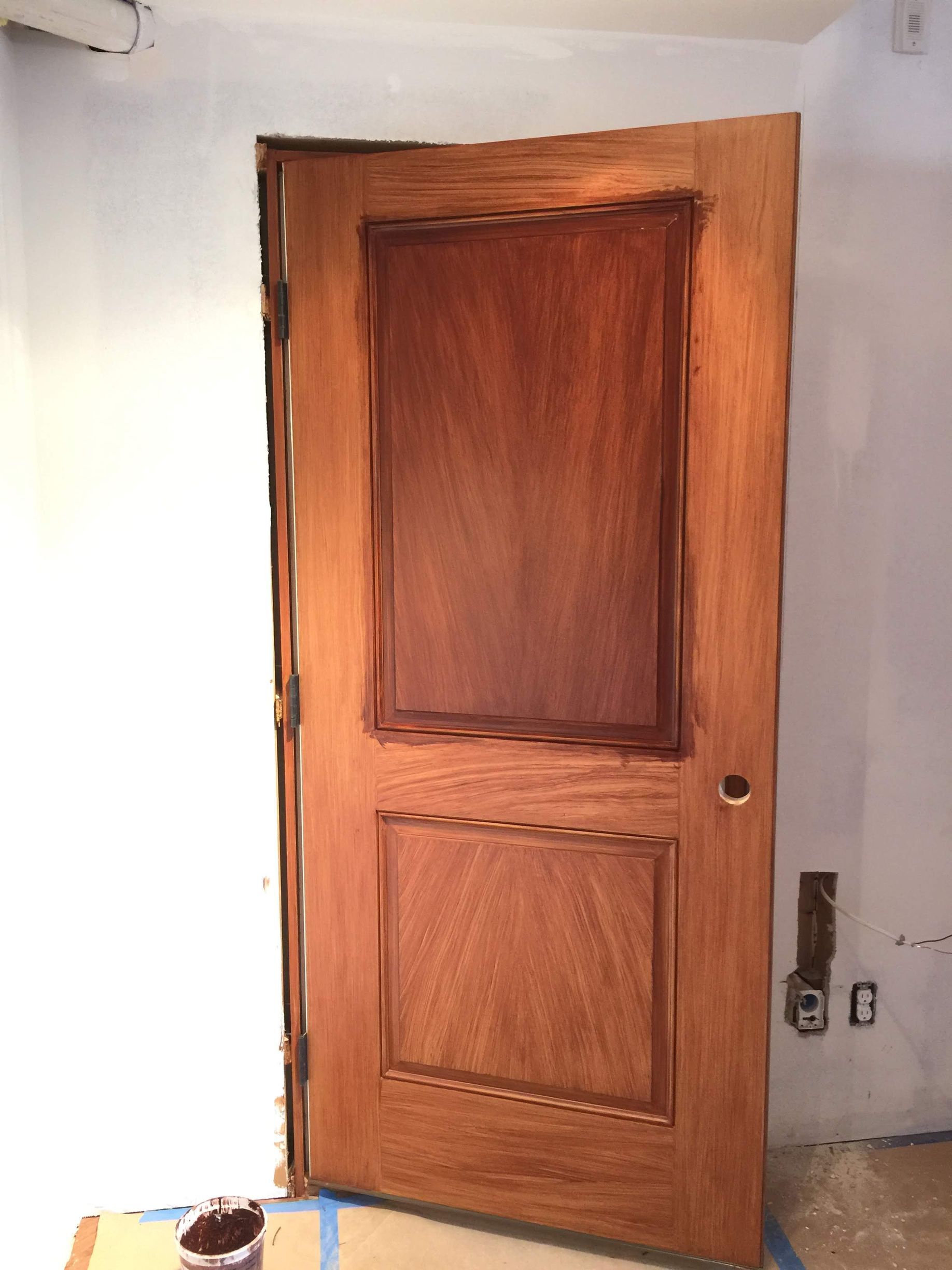 A wooden door is being painted in a room