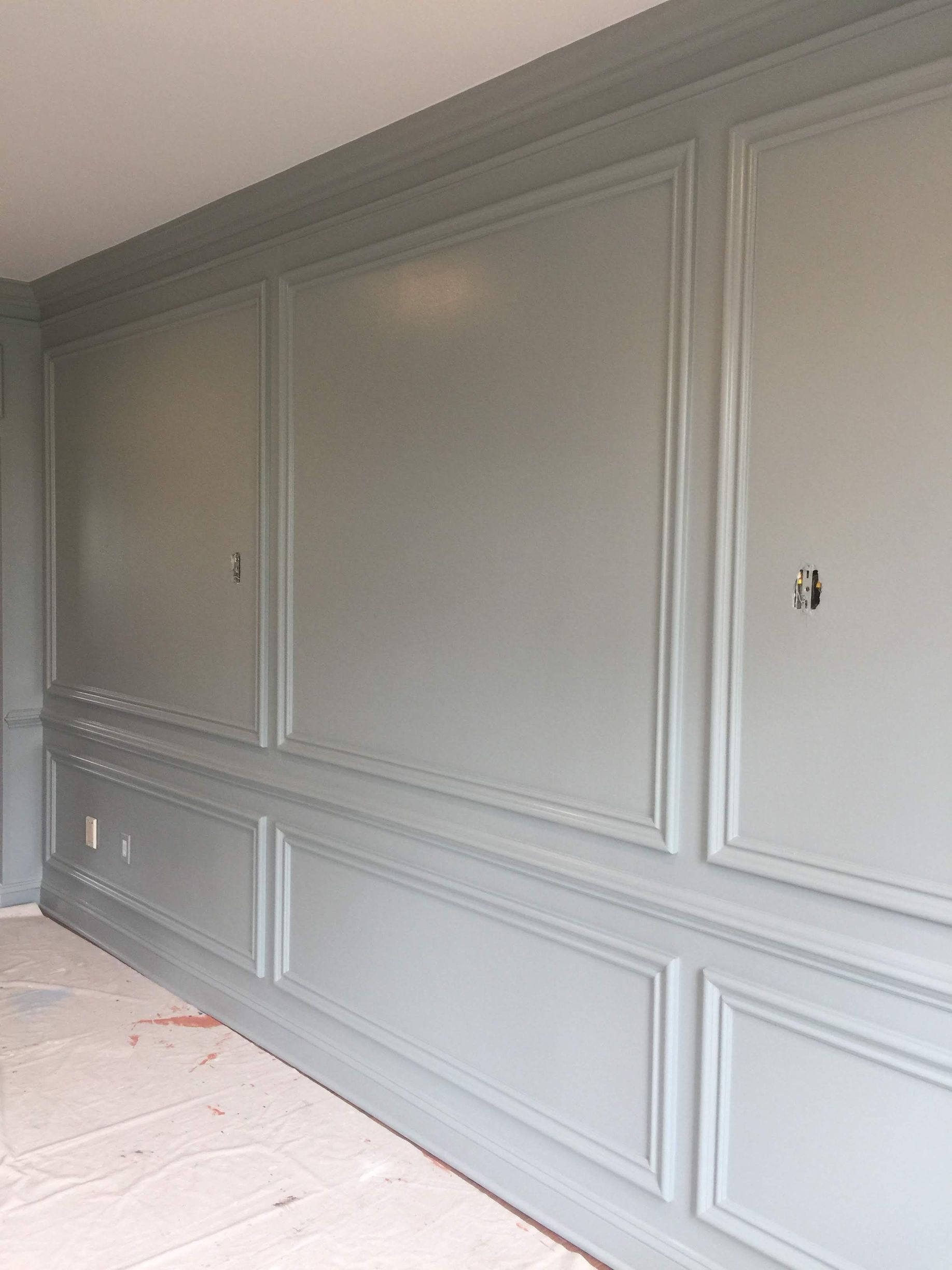 A room with a gray wall and a white floor.