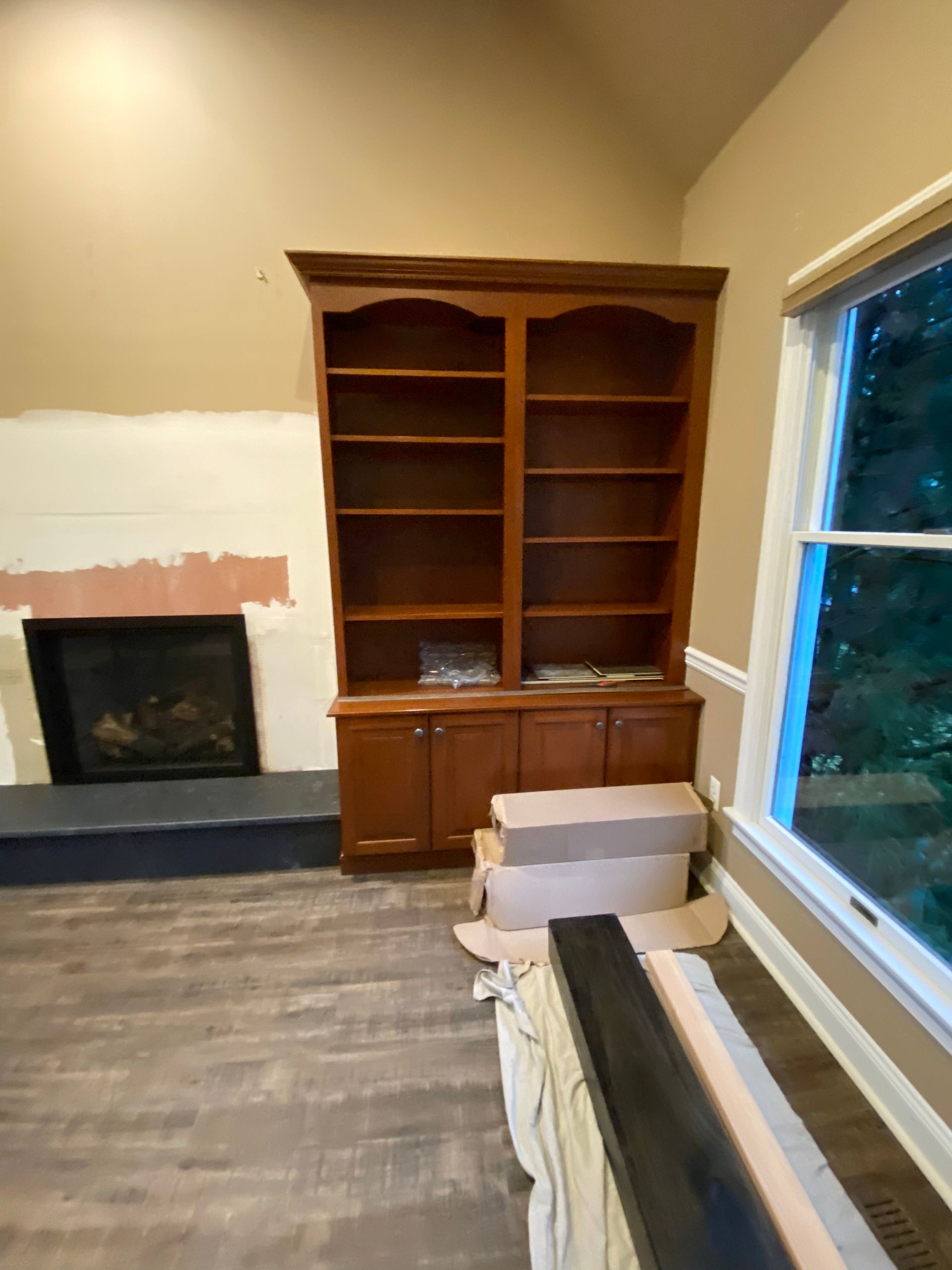 A living room with a fireplace and a bookshelf.