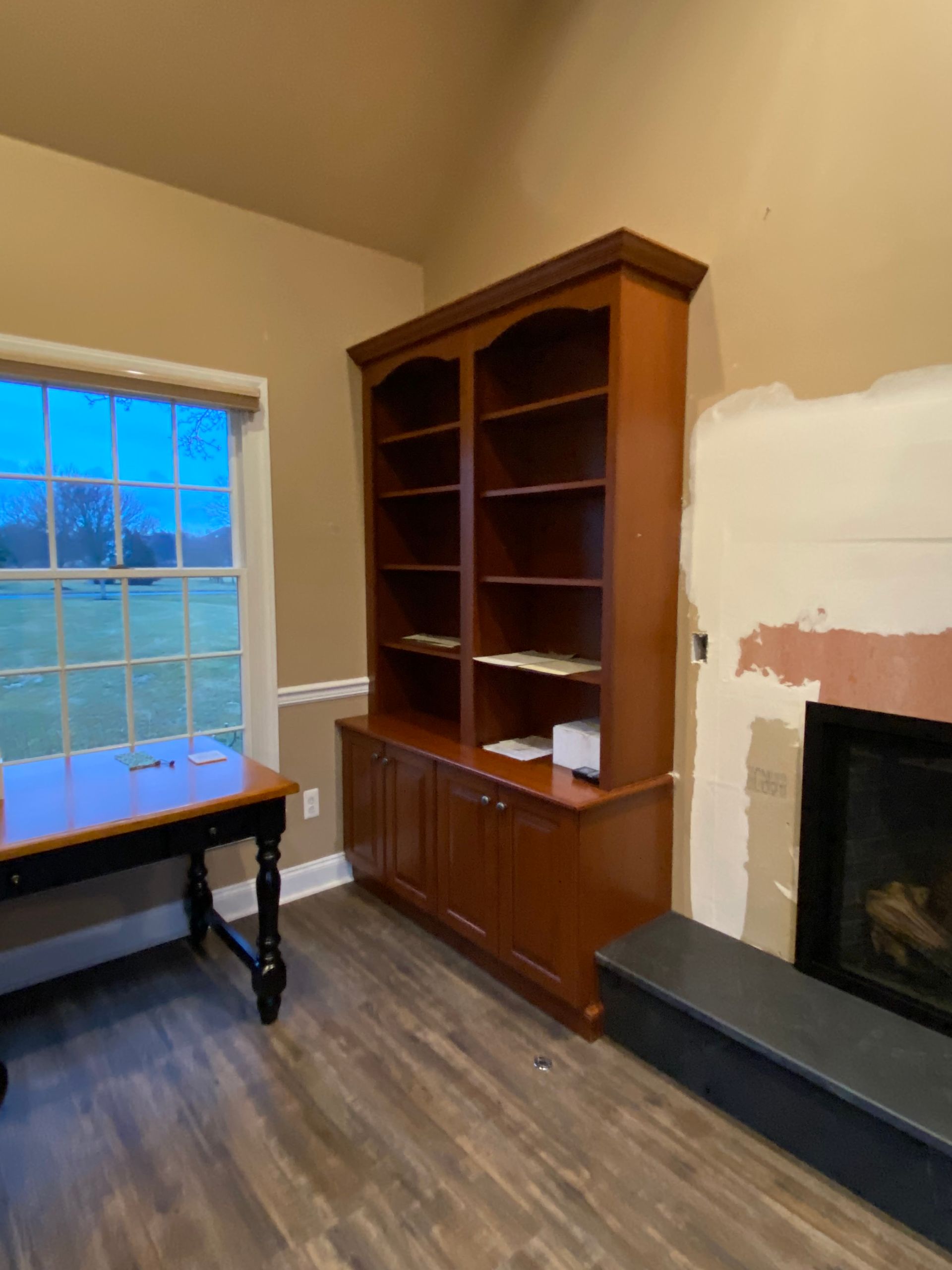 A living room with a fireplace and a bookshelf