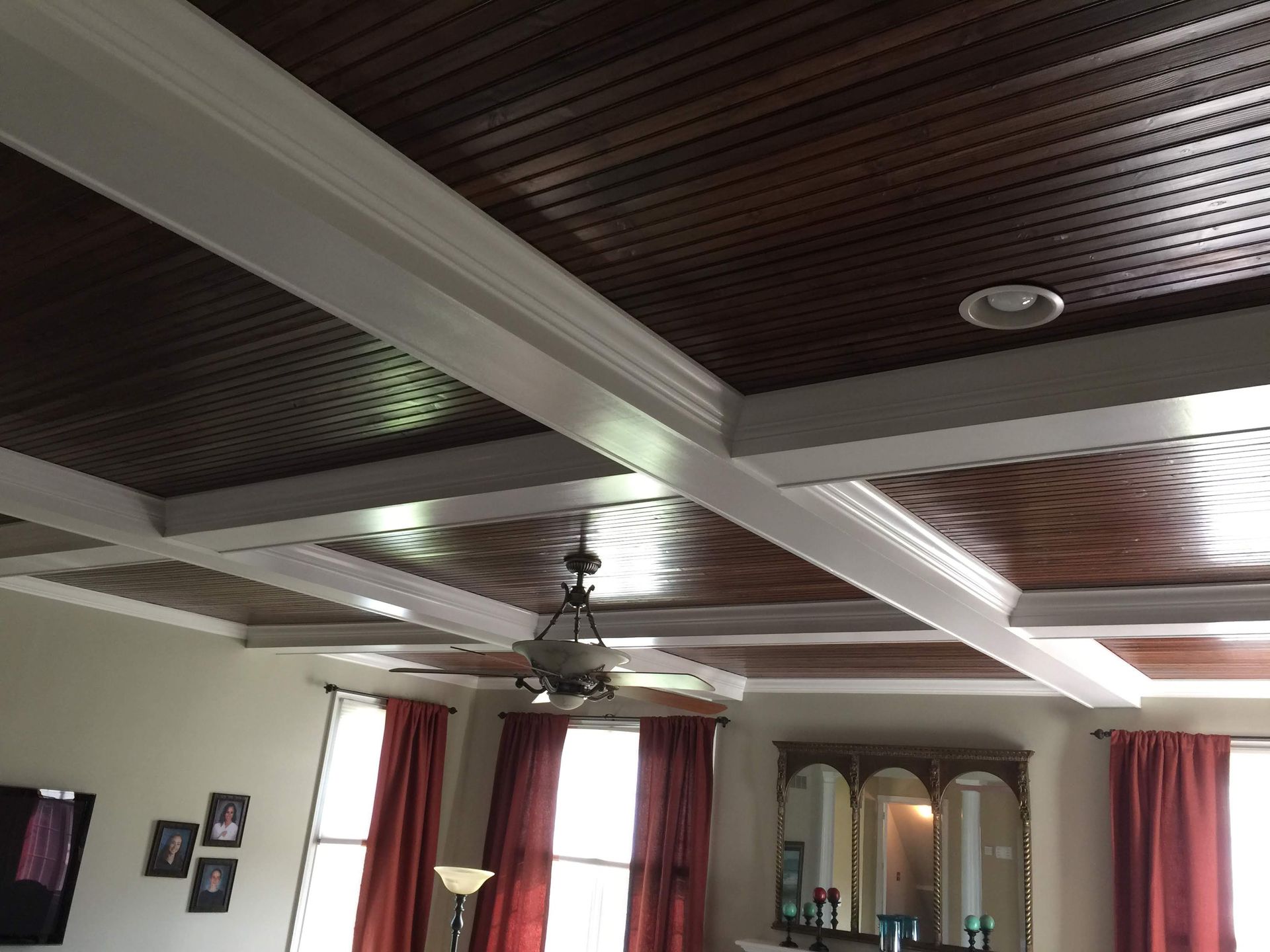 A living room with a wooden ceiling and a ceiling fan