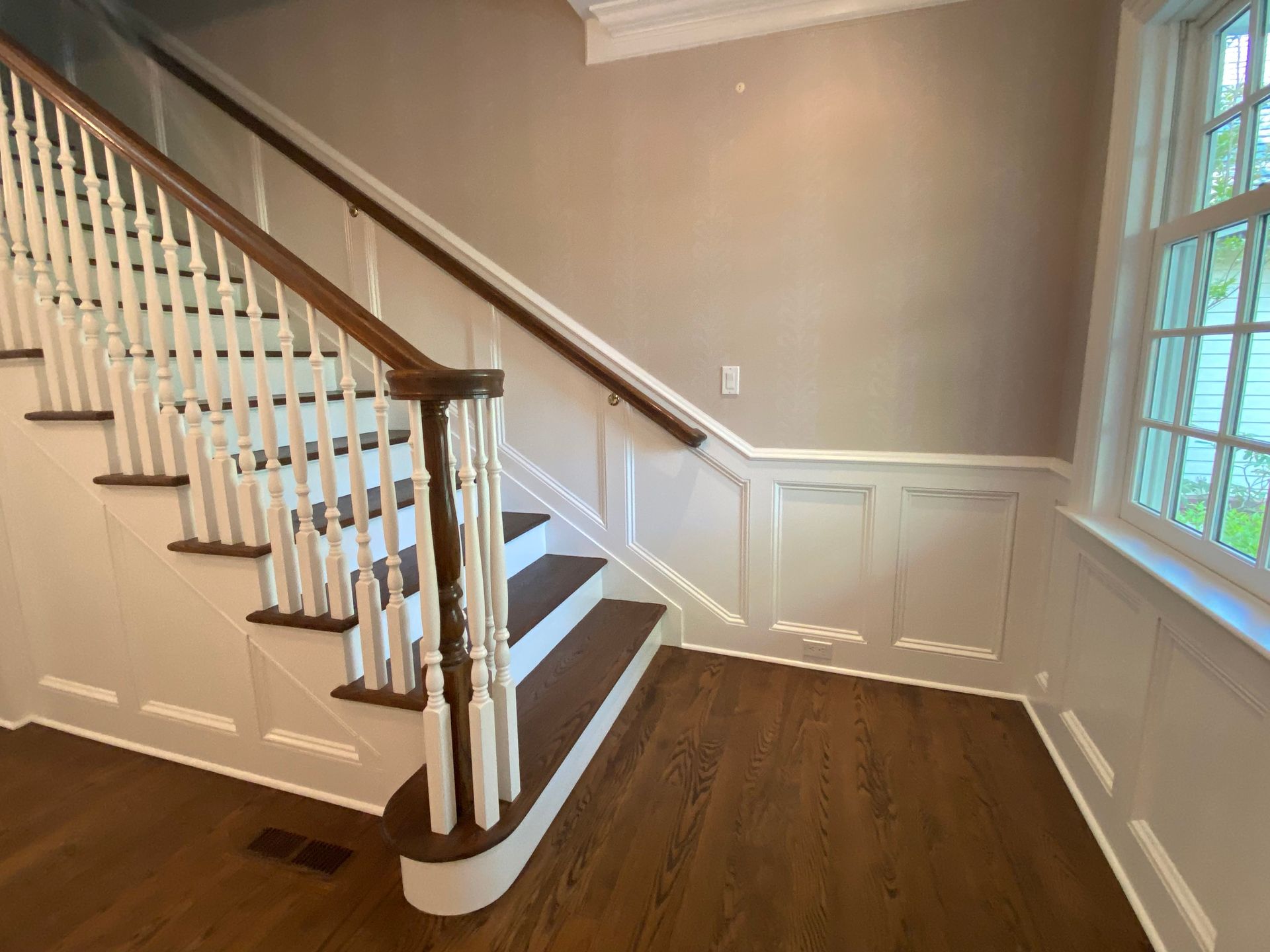 An empty room with a staircase and a window.