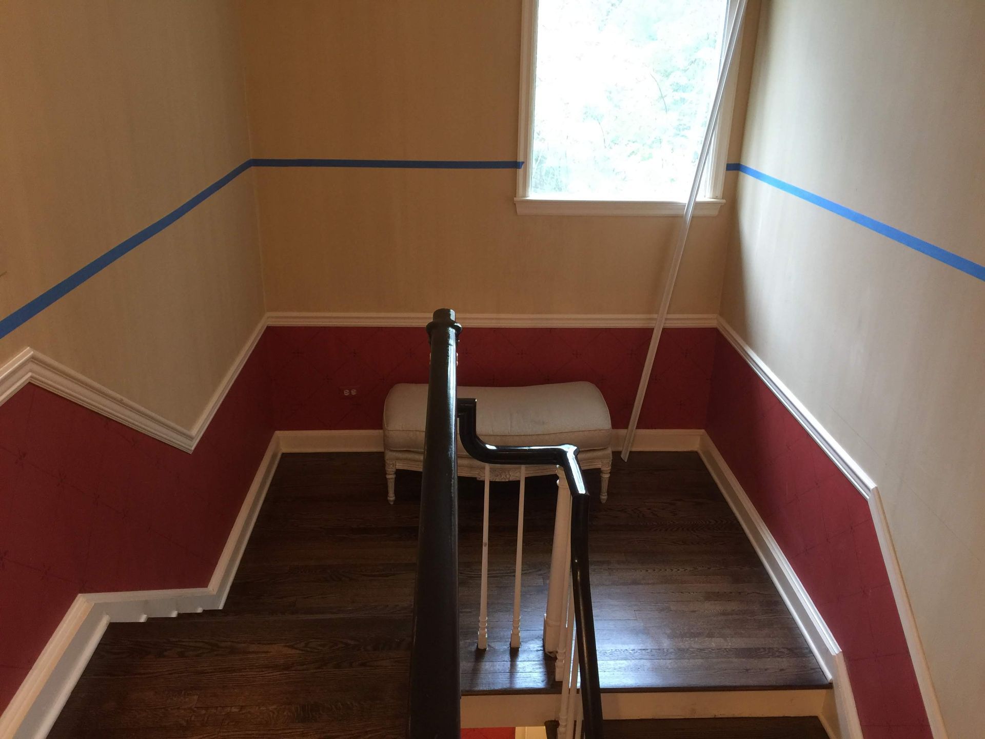 A staircase with red and white walls and a window