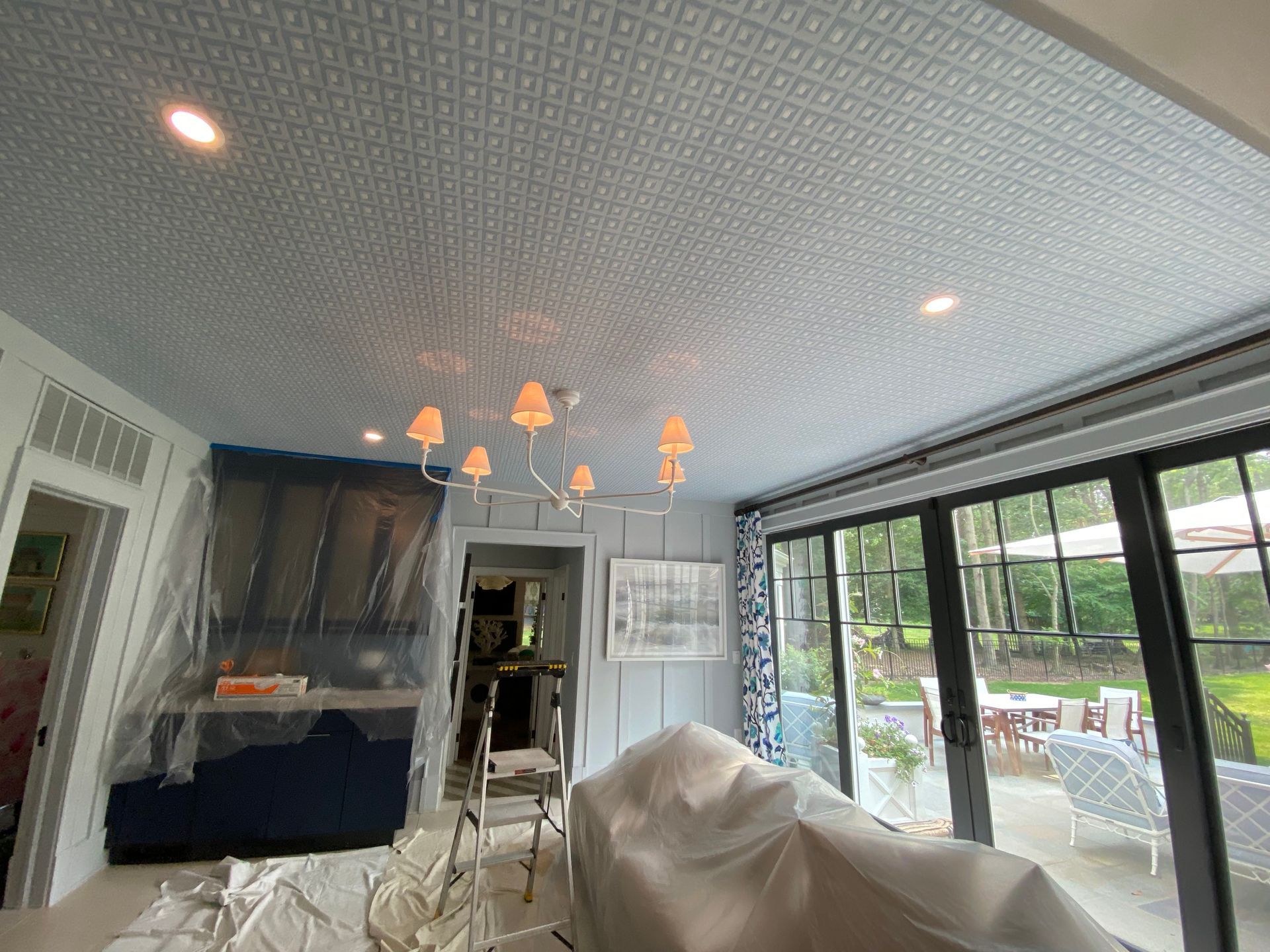 A living room with a chandelier hanging from the ceiling.