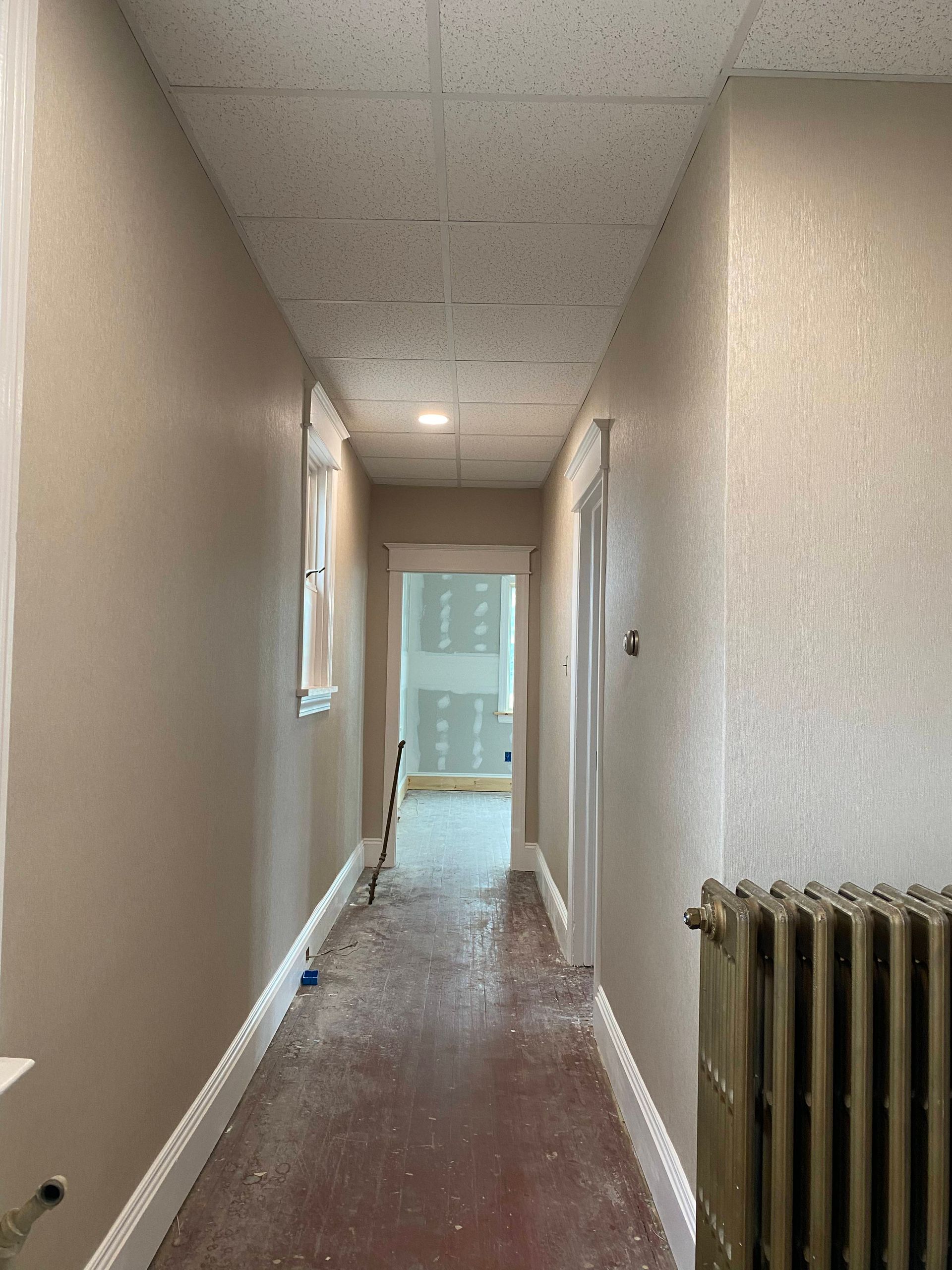 A long hallway with a radiator in the corner