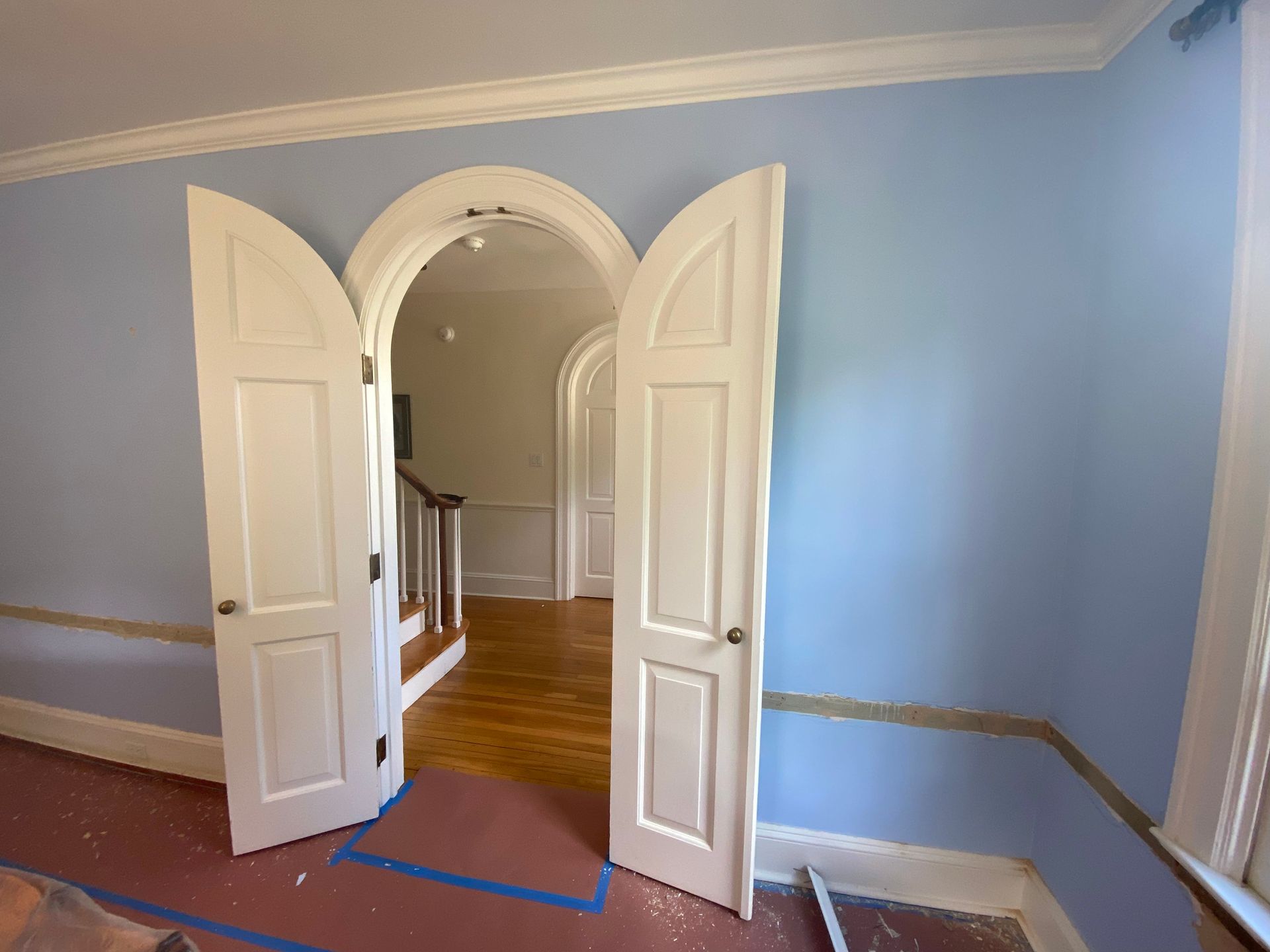 A room with blue walls and white doors that are open