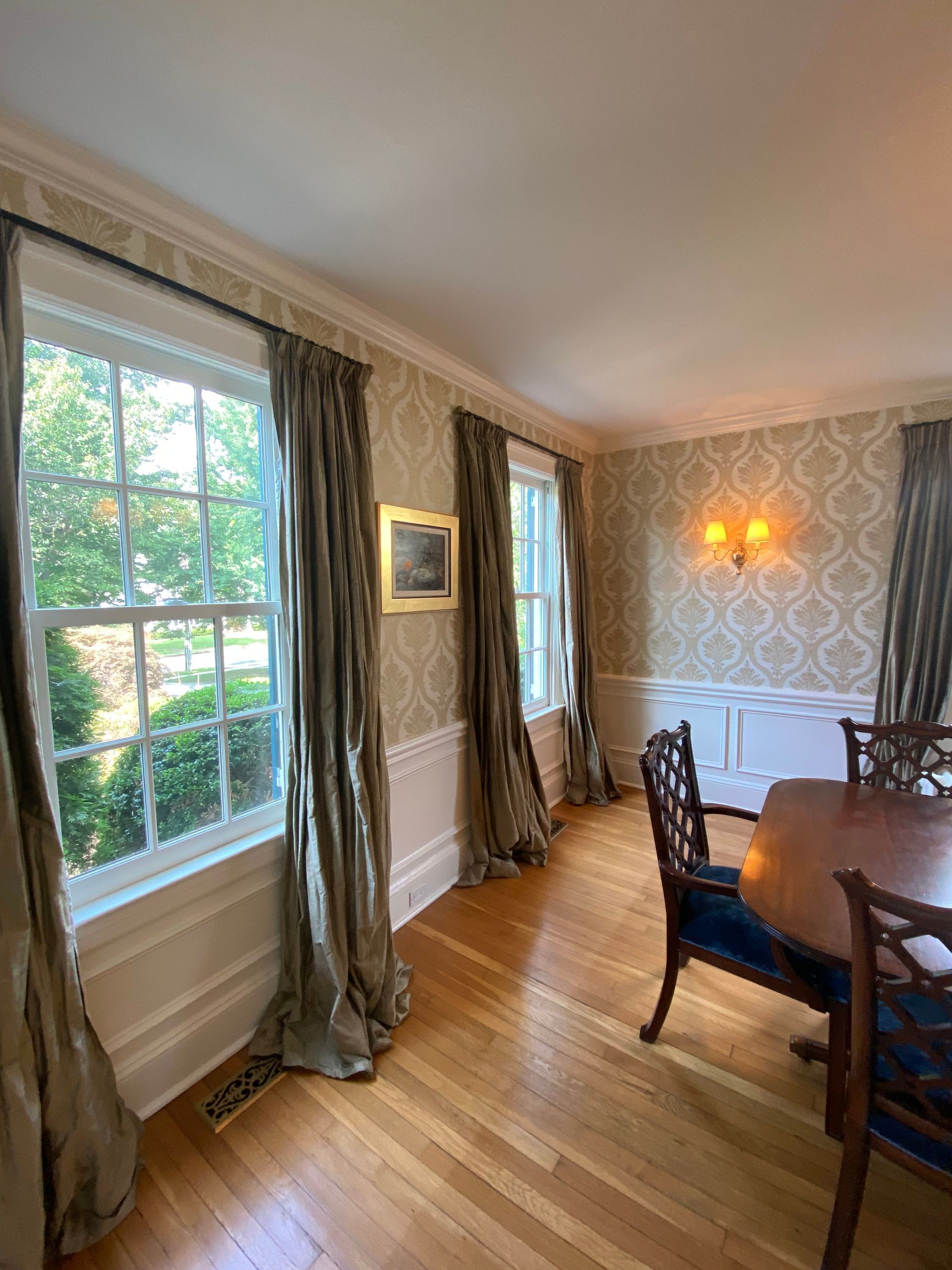 A dining room with a table and chairs and lots of windows.