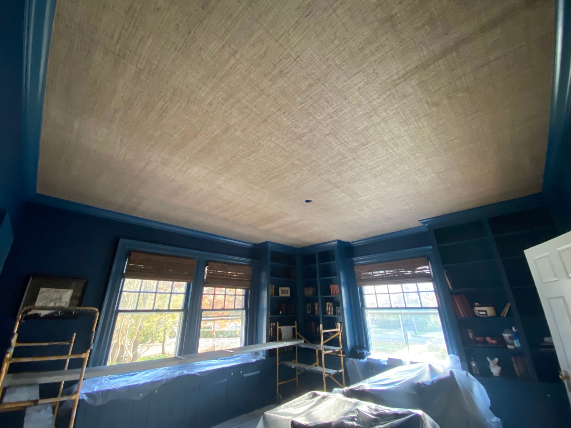 A living room with blue walls and a wooden ceiling.